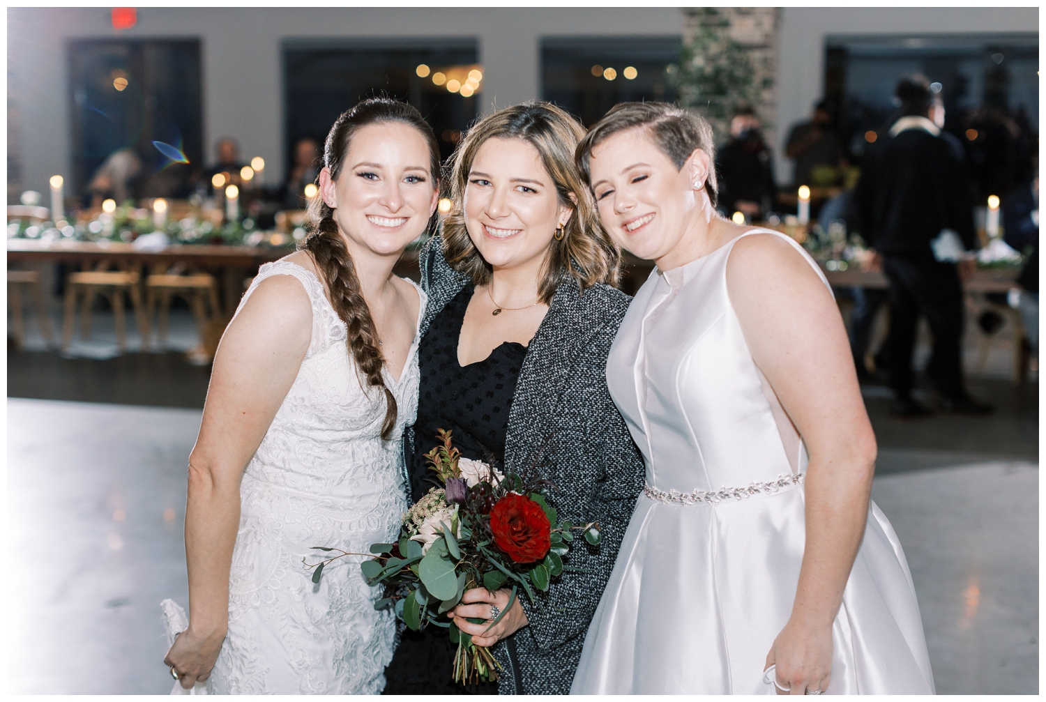 brides posing with guest from bouquet toss