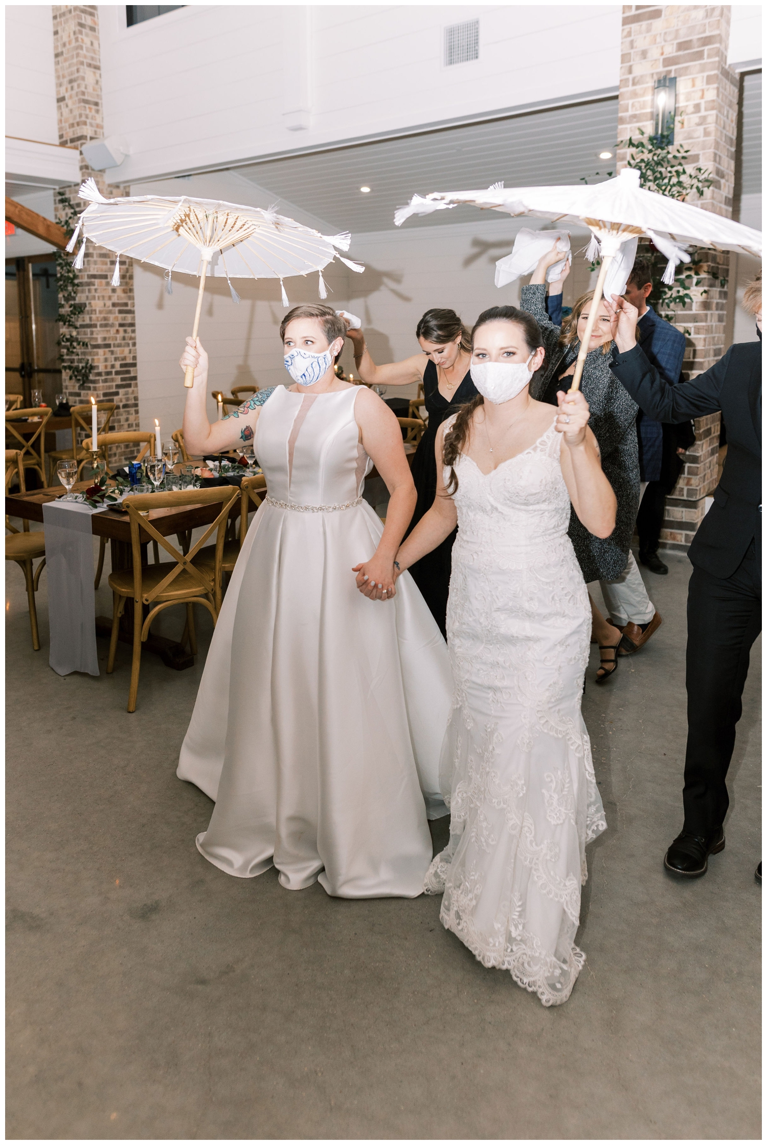 brides holding parasols at wedding reception