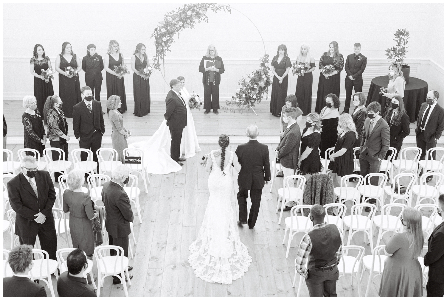 black and white photo of bride and father walking down wedding aisle