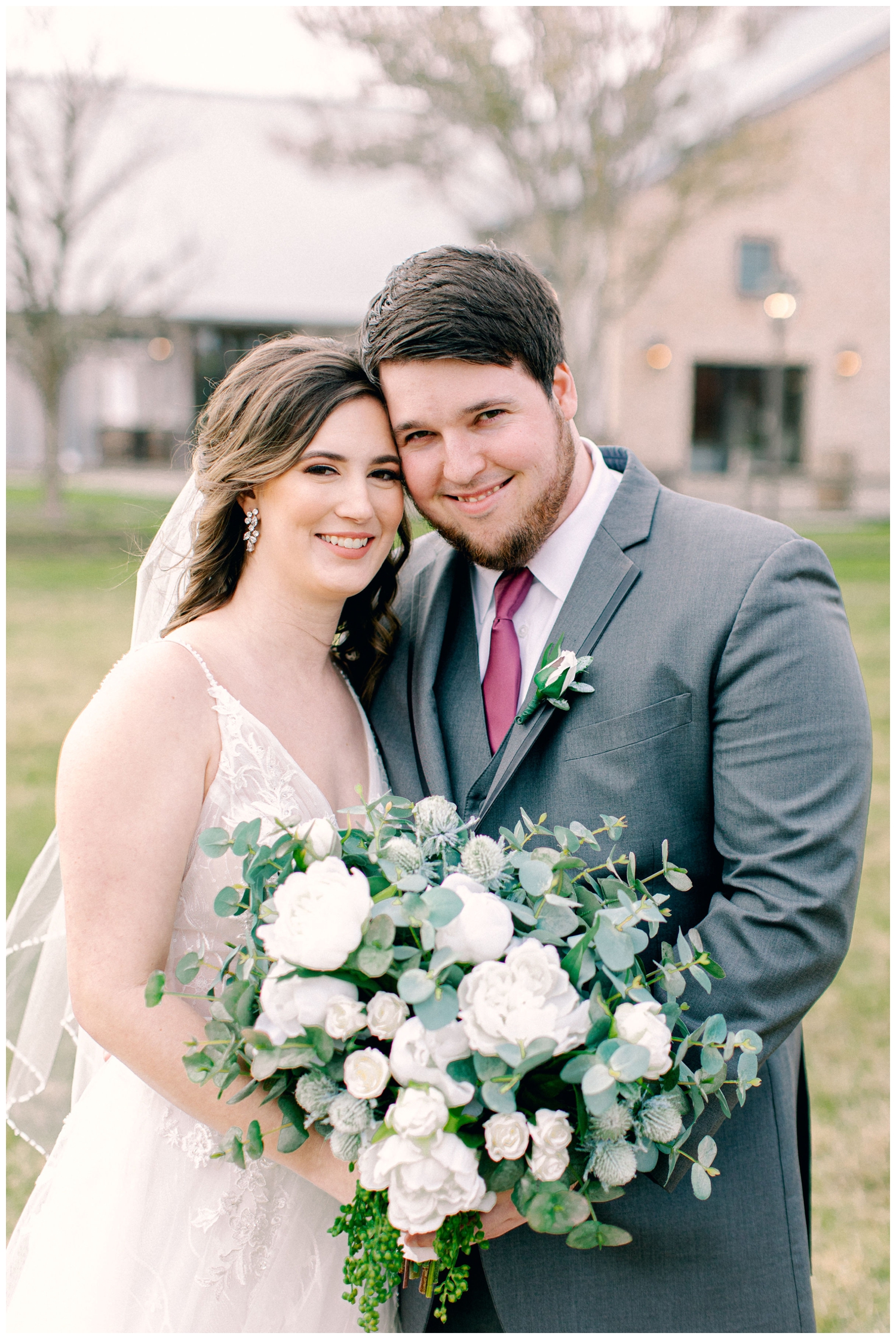 bride and groom closeup holding white floral bouquet