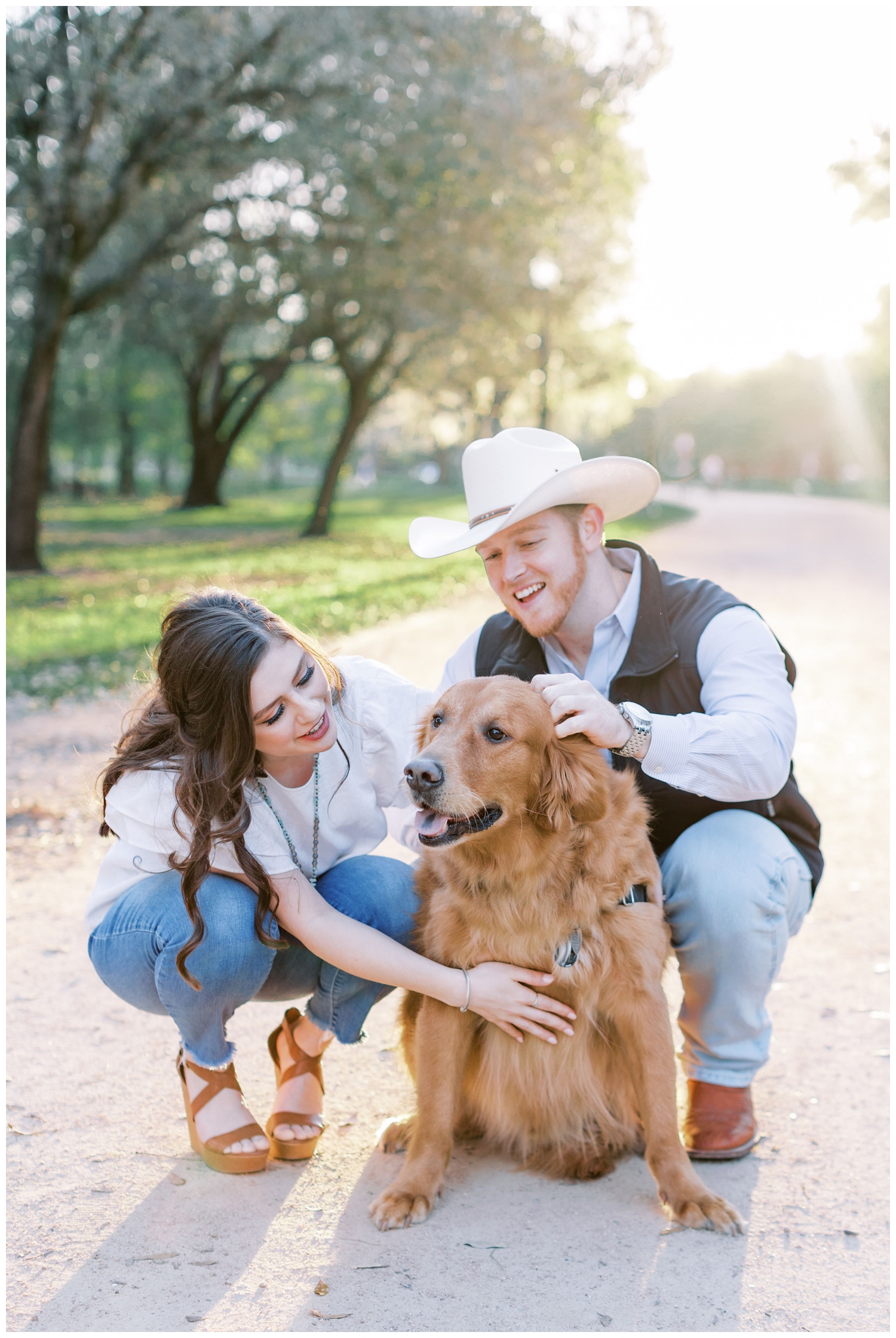 couple posing and petting a dog