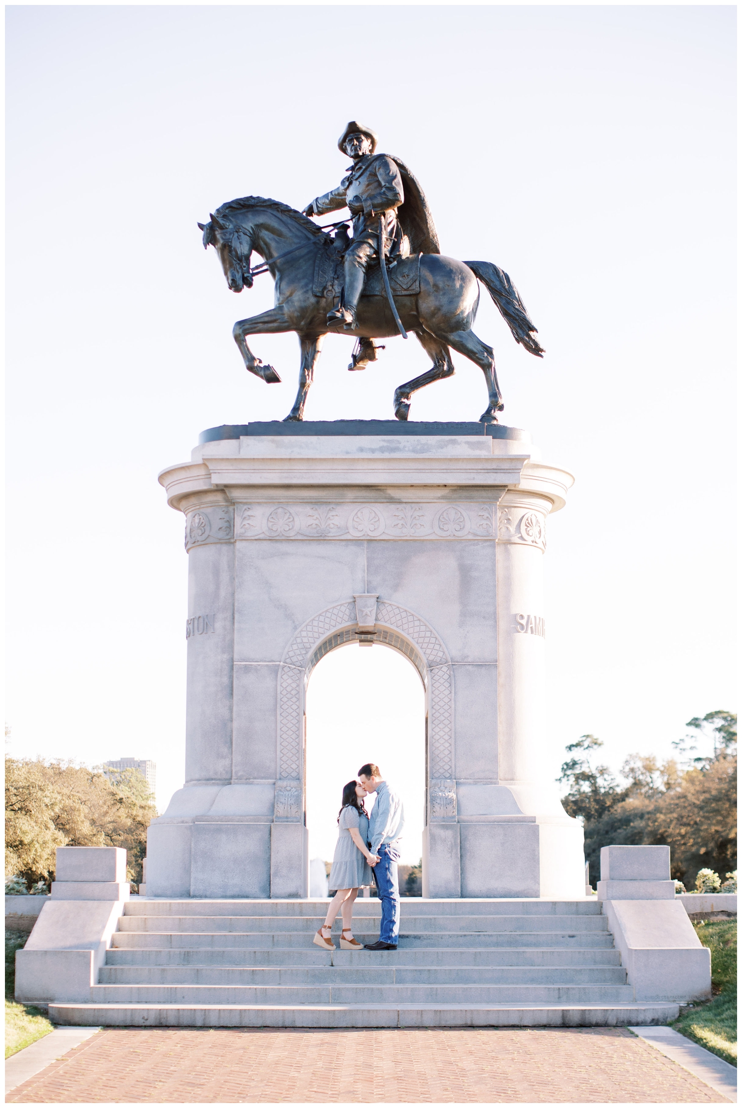 couple standing in front of monument at Houston engagement session