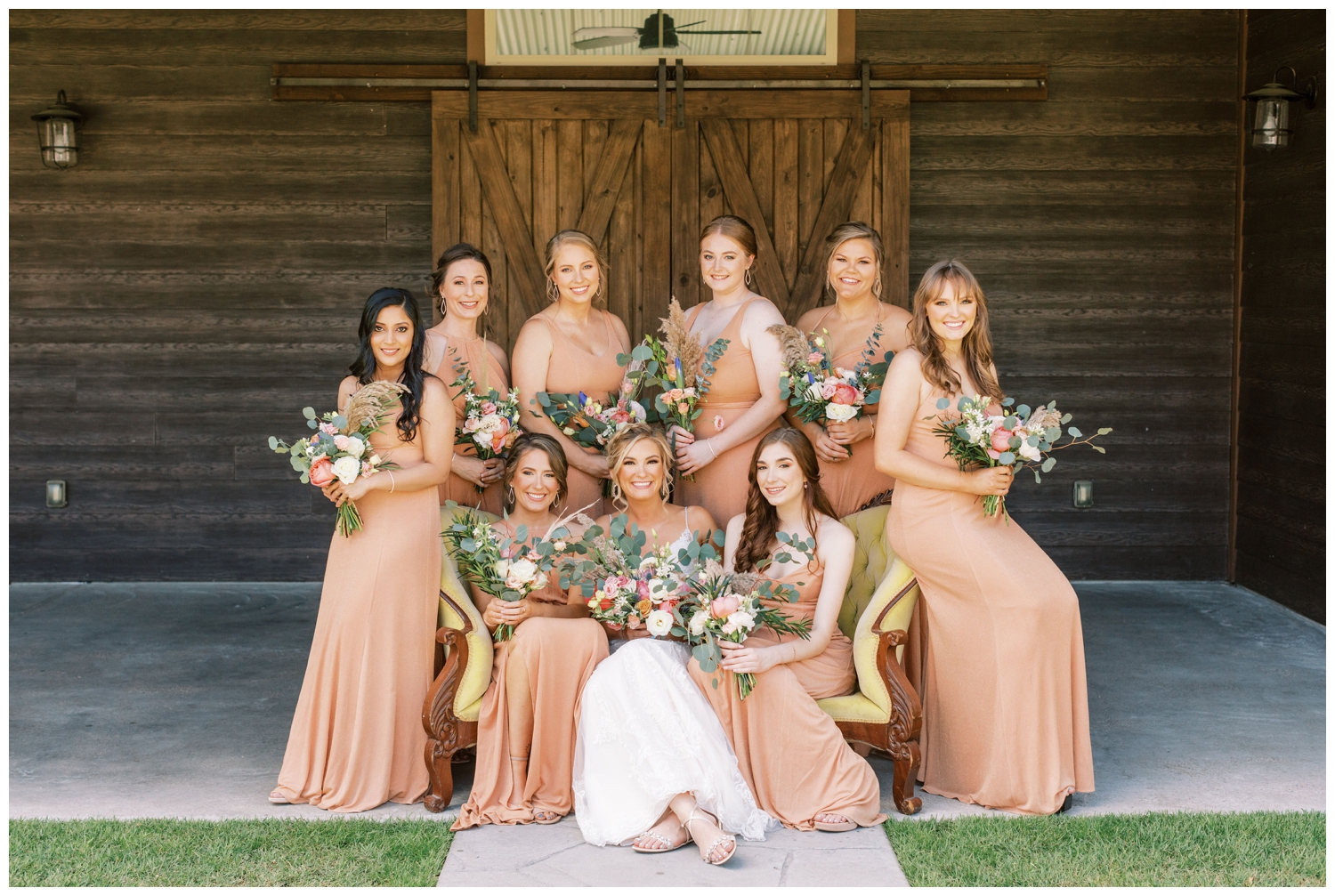 bridesmaids and brides sitting on yellow couch in front of barn door Peach Creek Ranch Wedding venue