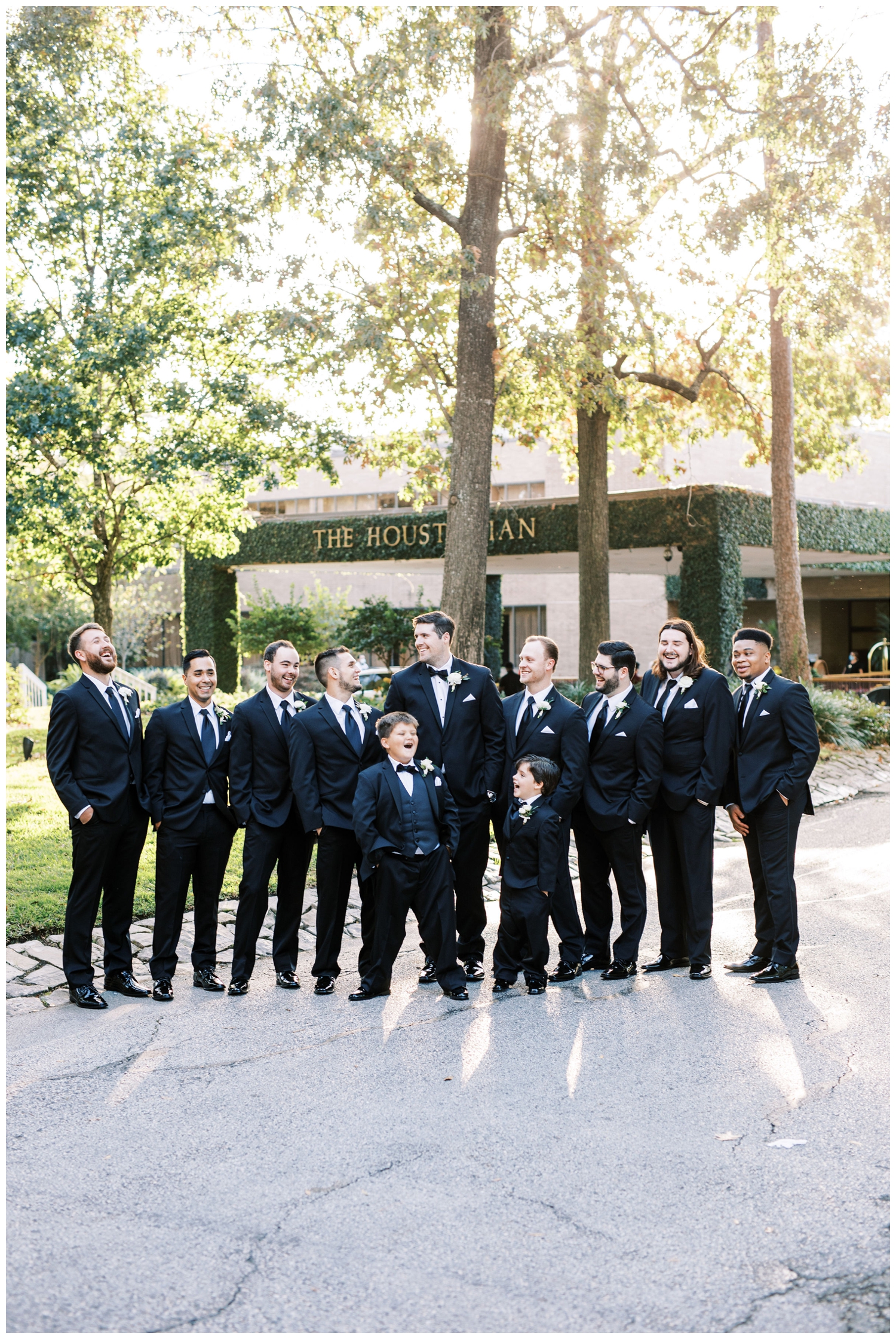 groom and groomsmen in black tuxes standing on the lawn on the Houstonian Hotel wedding