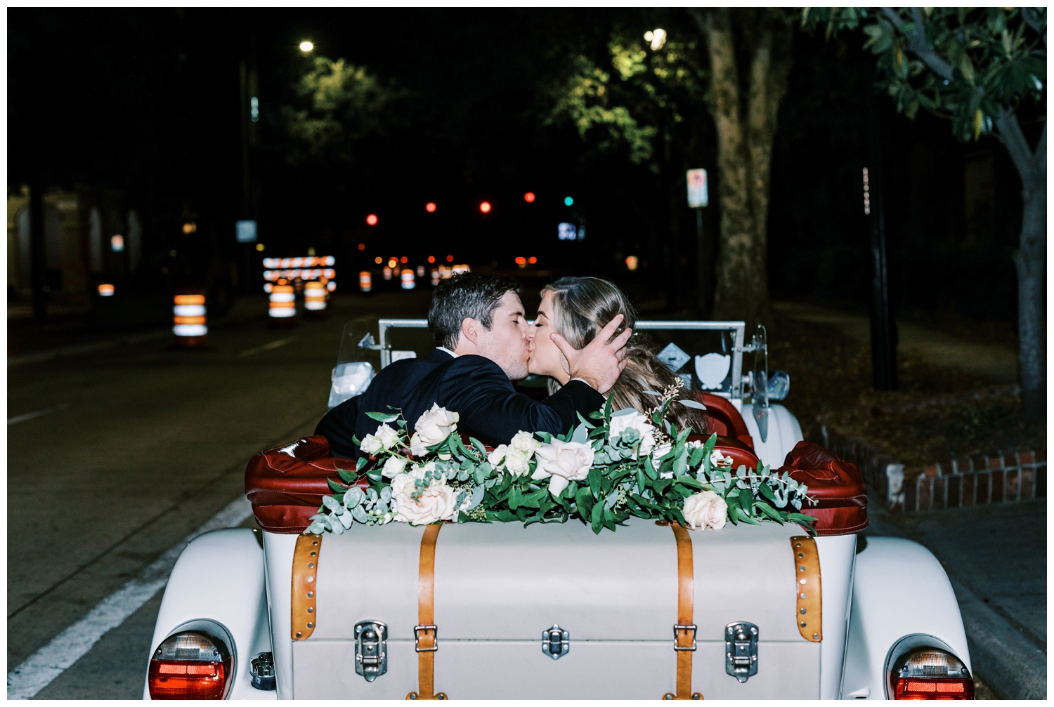 newlyweds kissing inside a vintage getaway car