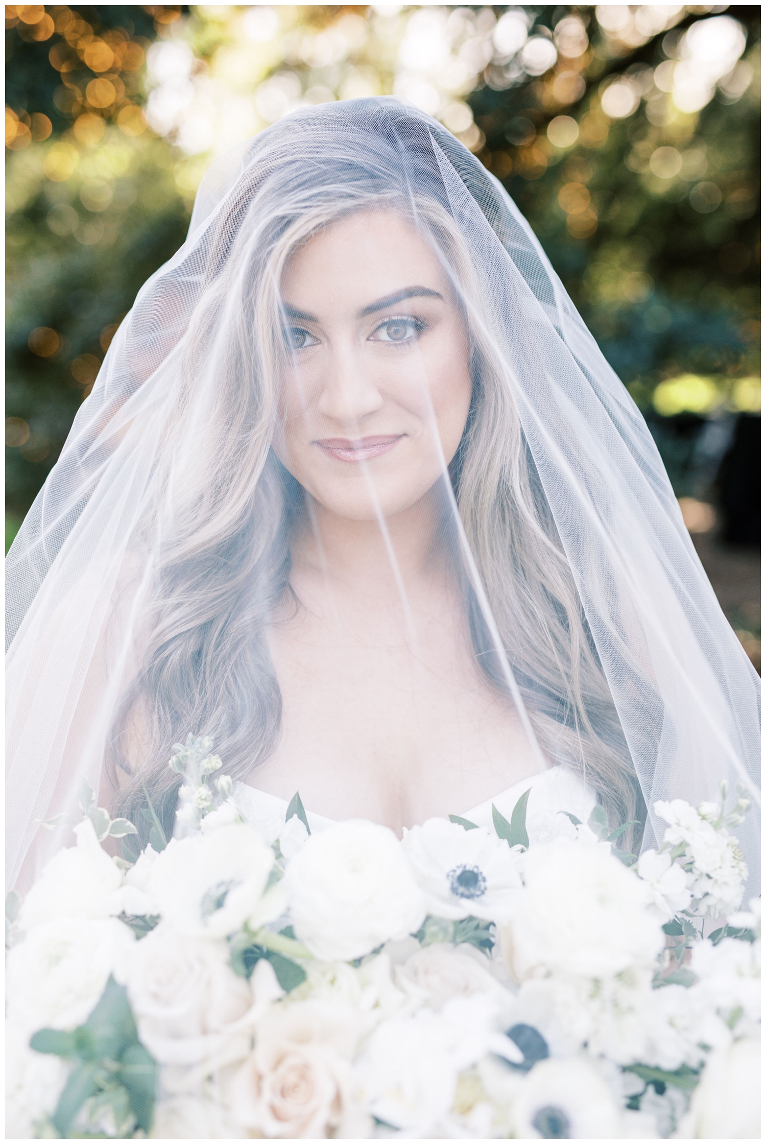 bride smiling at camera under her veil outside the Houstonian Hotel wedding