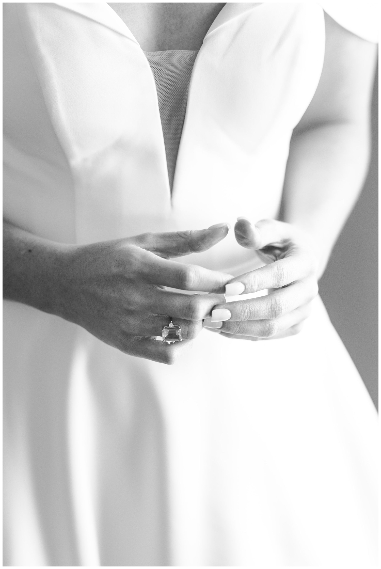 black and white portrait of brides hands in front of wedding gown