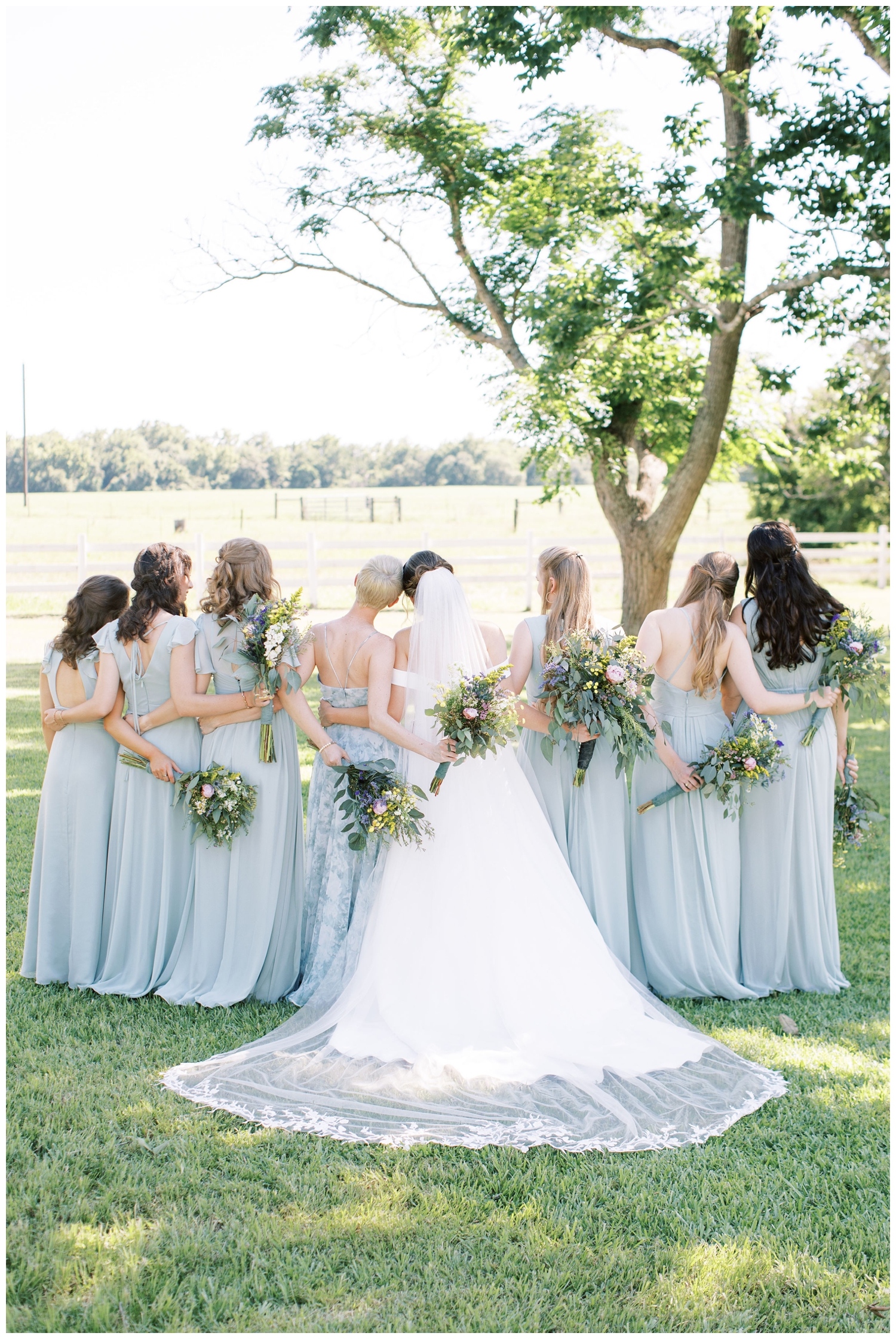 bridesmaid pale blues dresses with bride and bridesmaid shot from behind