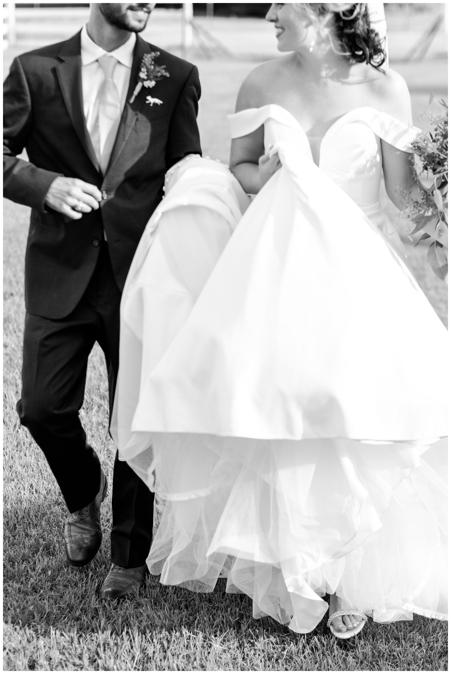black and white photo of bride and groom walking