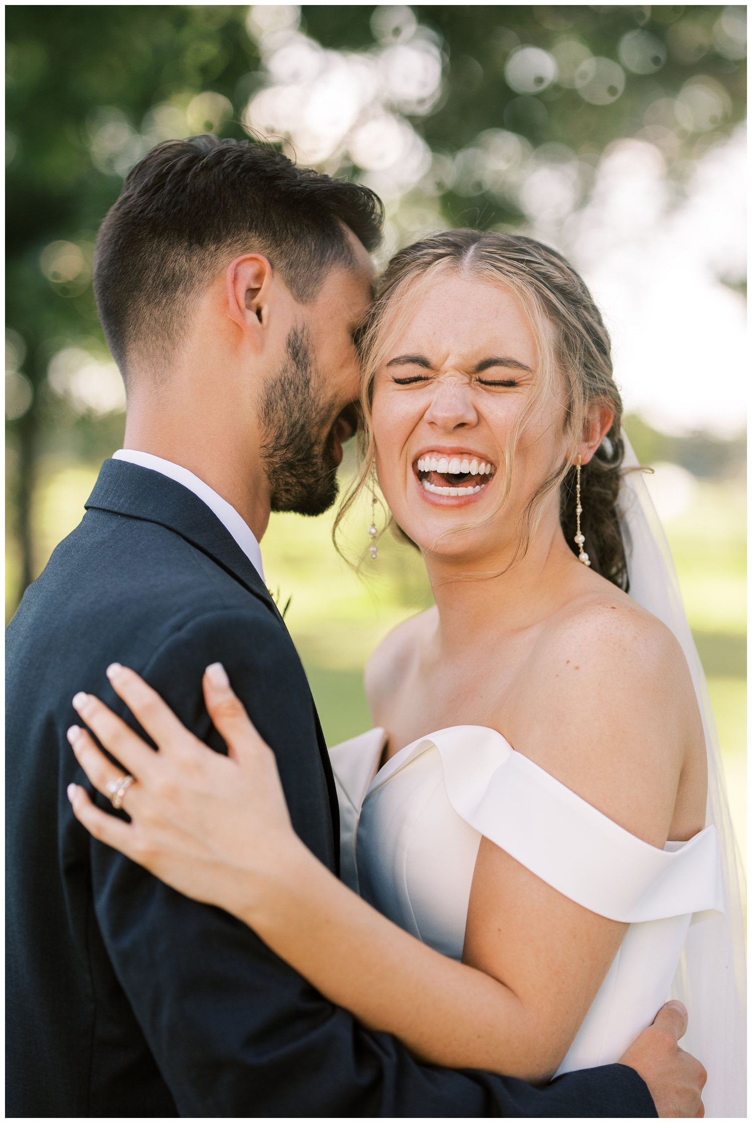 bride laughing while hugging groom