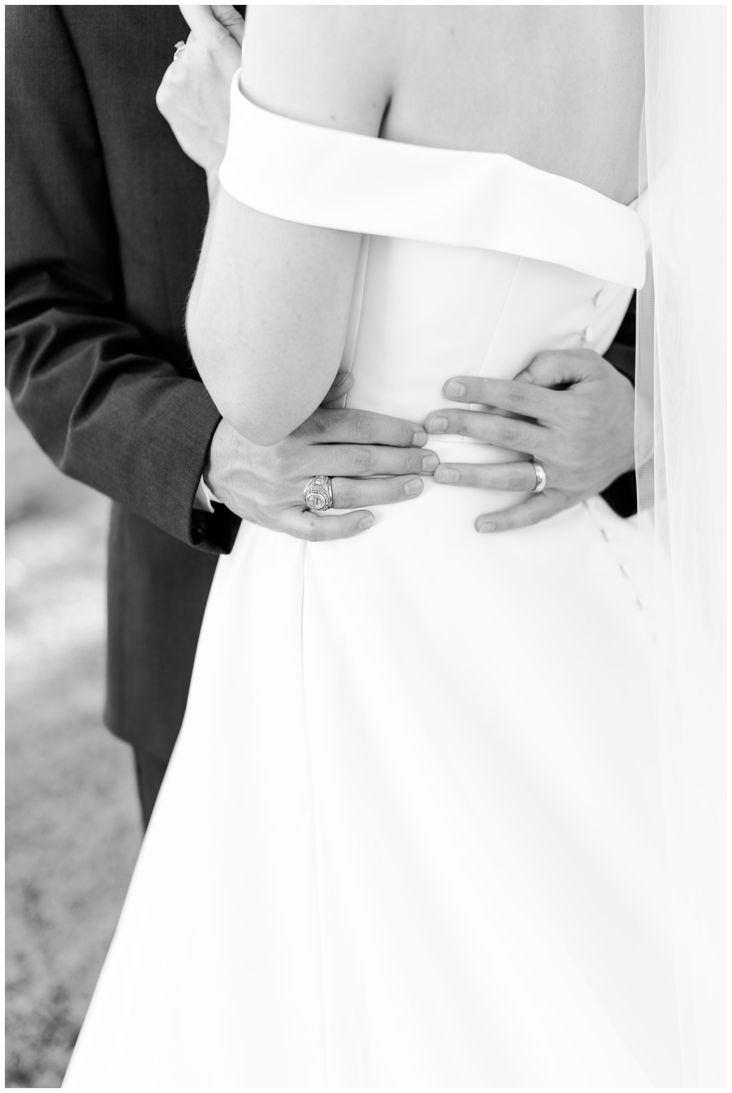 black and white photo of groom's hand around bride's waist