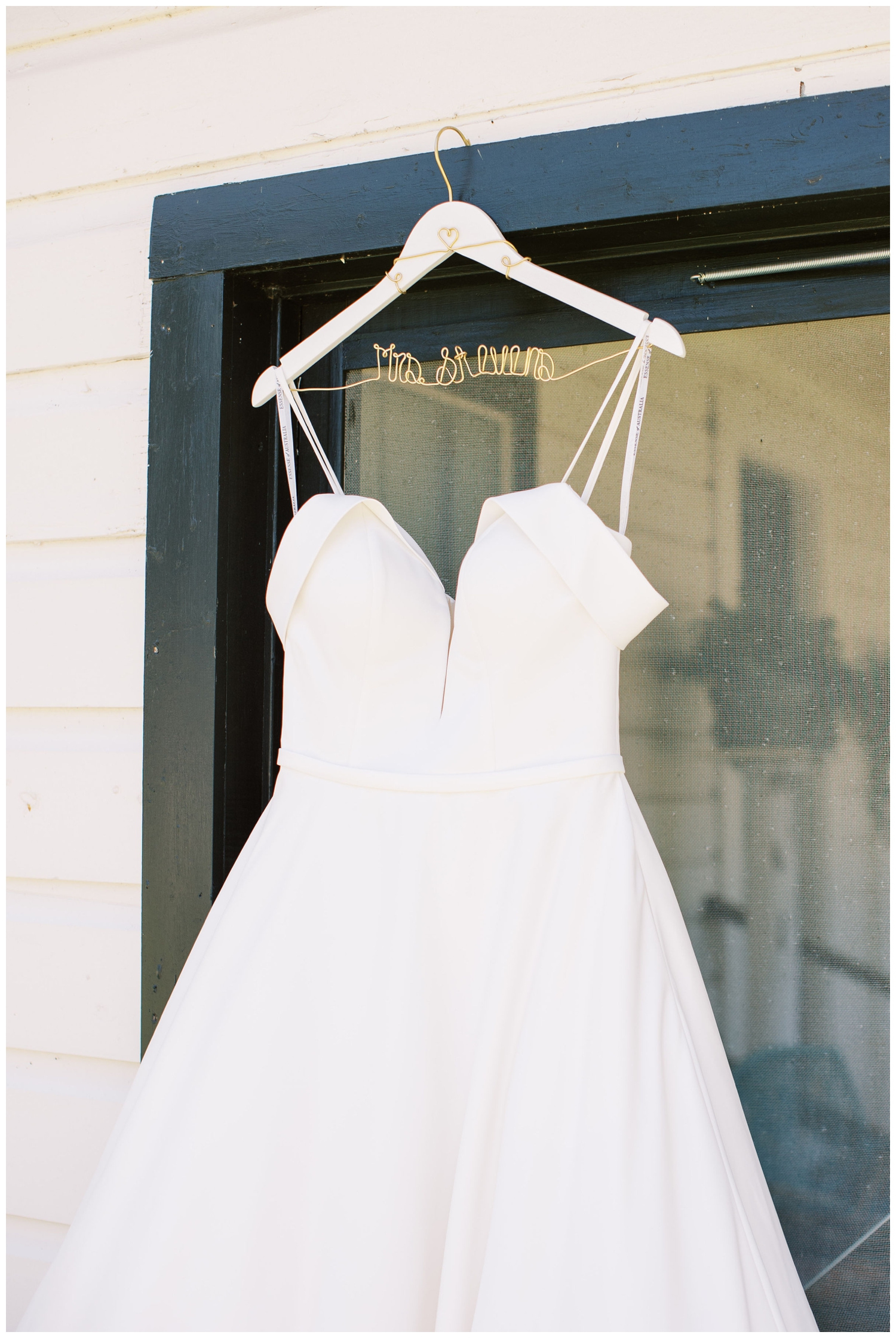 white wedding gown hanging from door
