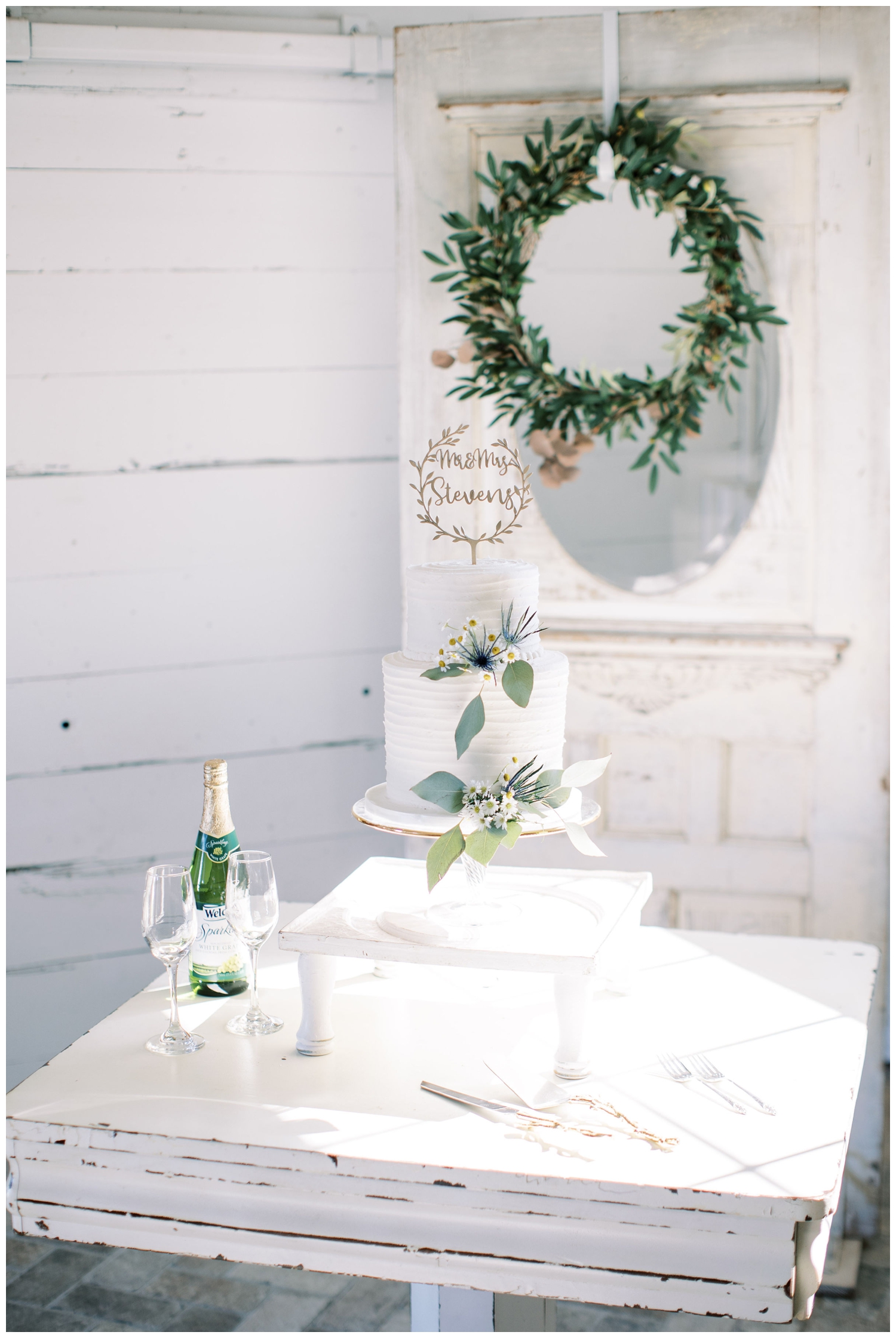 tiered white wedding cake with greenery