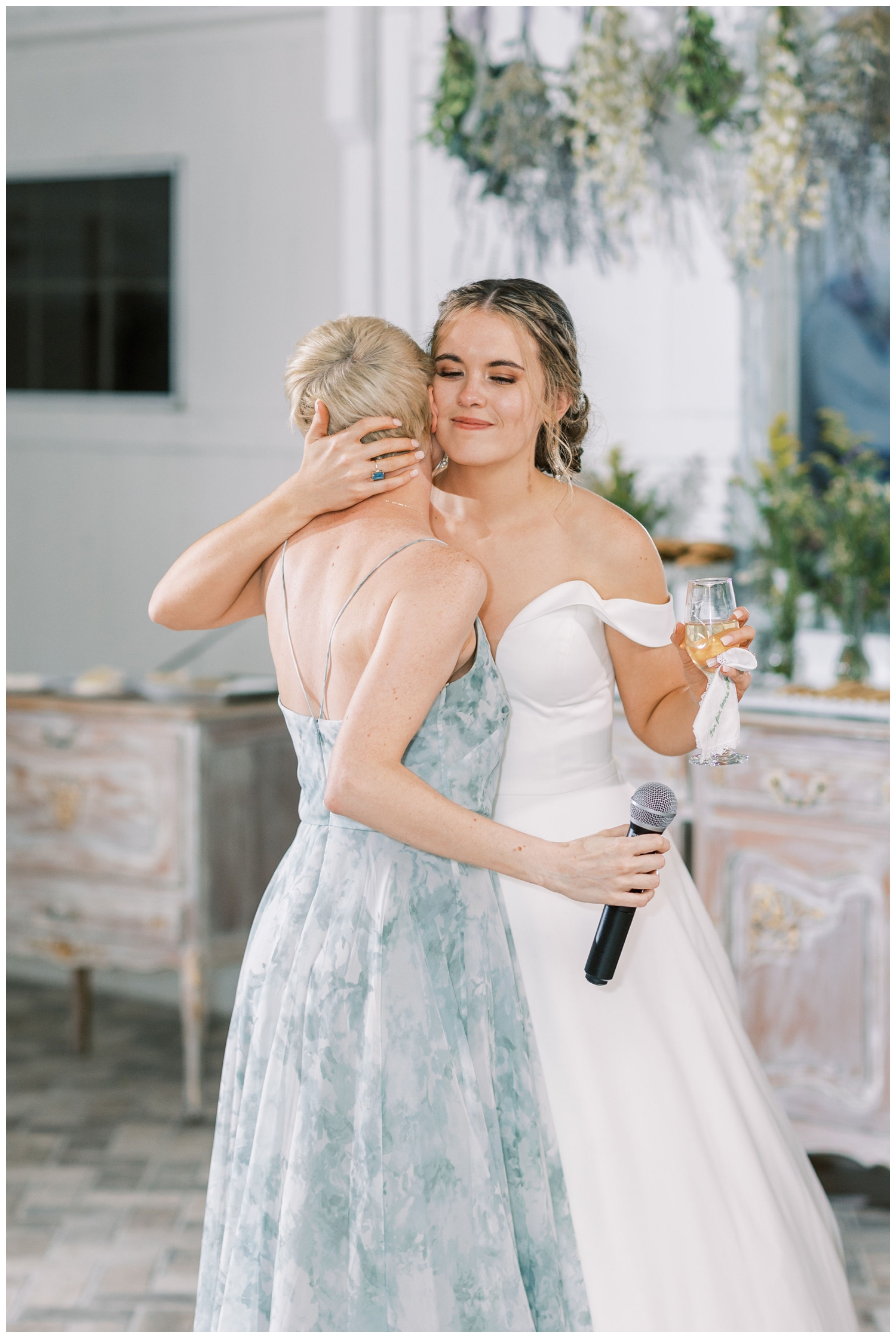 bride hugging guest at reception after toast