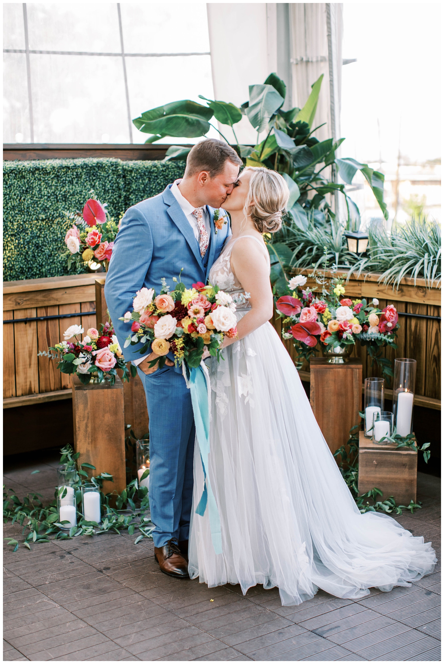 bride and groom kissing by floral installations
