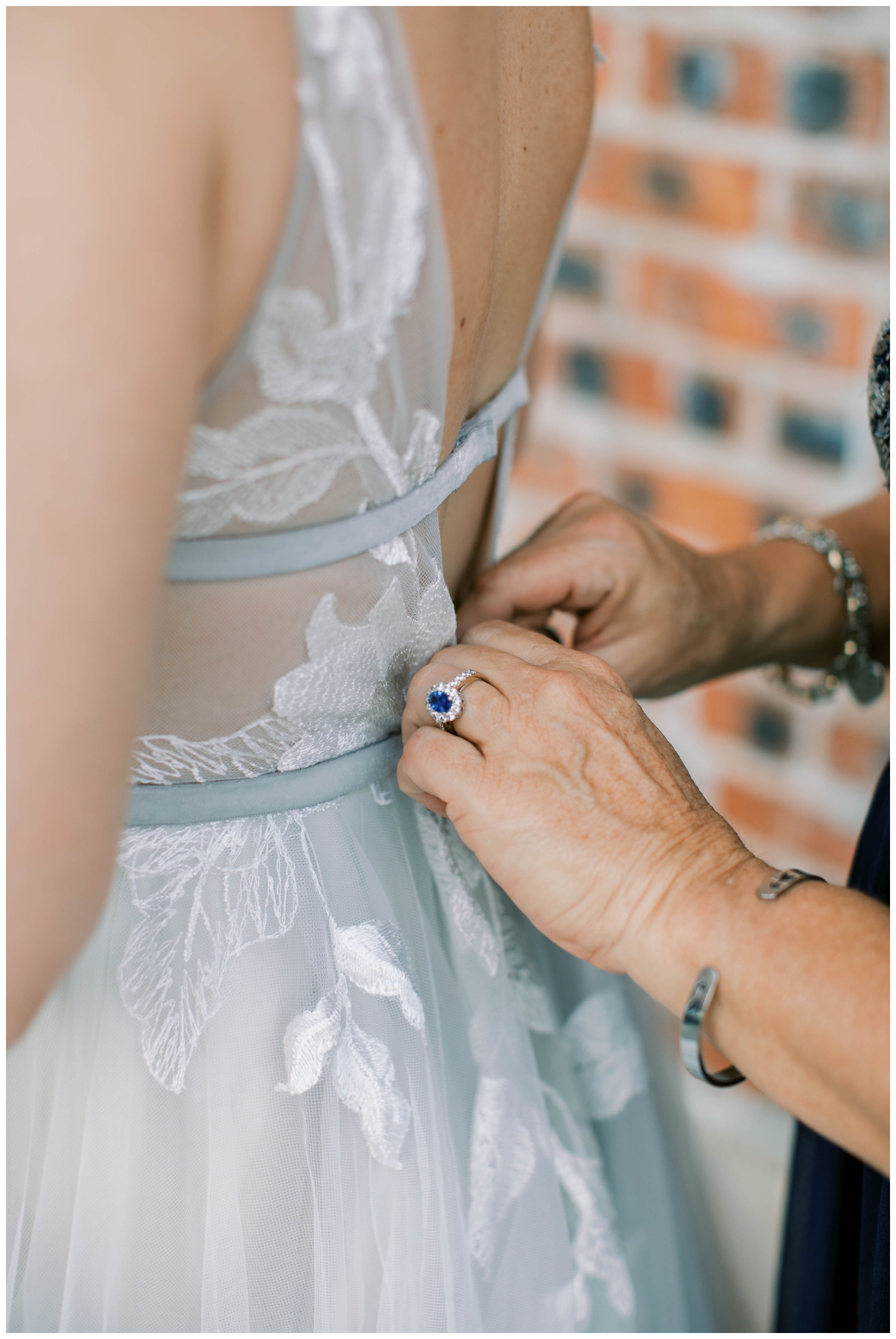 hands buttoning wedding gown