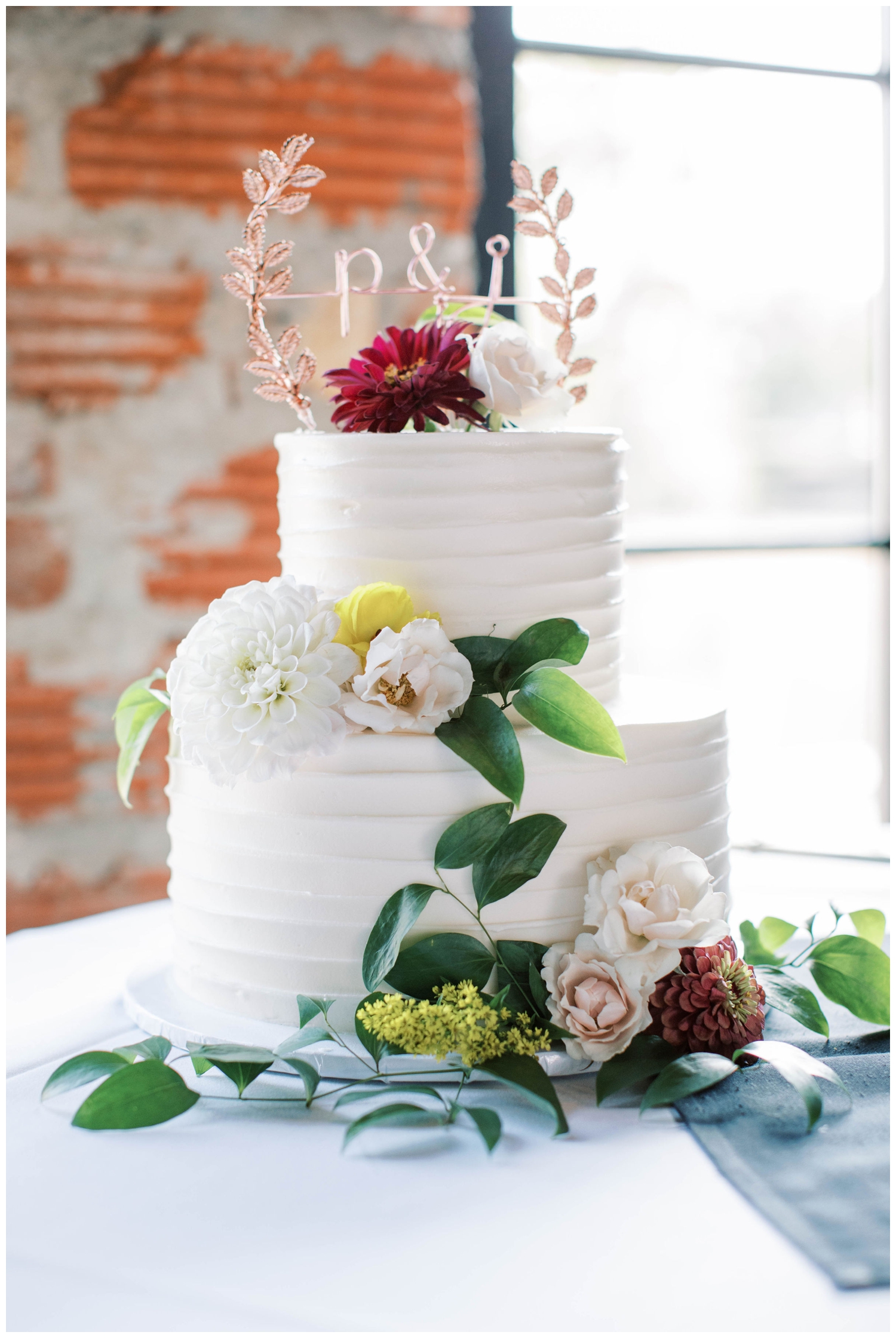 two tier white cake with florals for Houston wedding reception