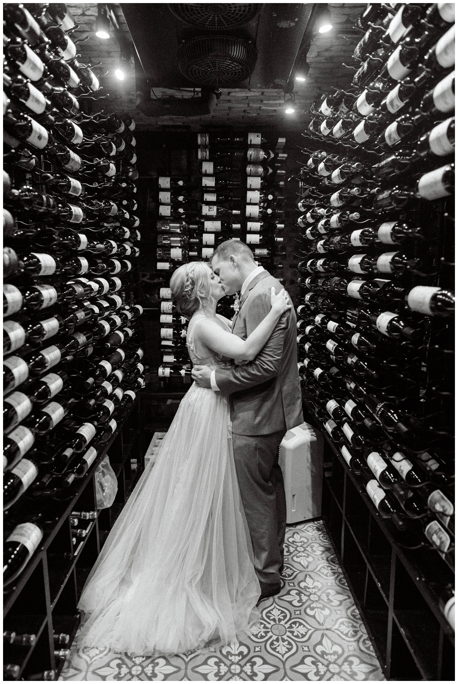 bride and groom kissing in wine cellar