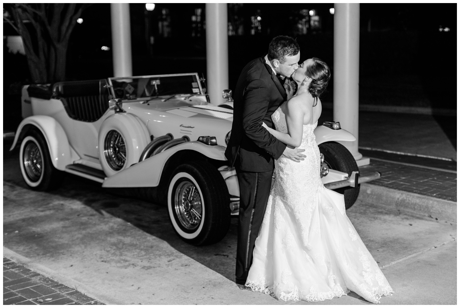 bride and groom kissing in front of classic car Houston Junior League Wedding Reception
