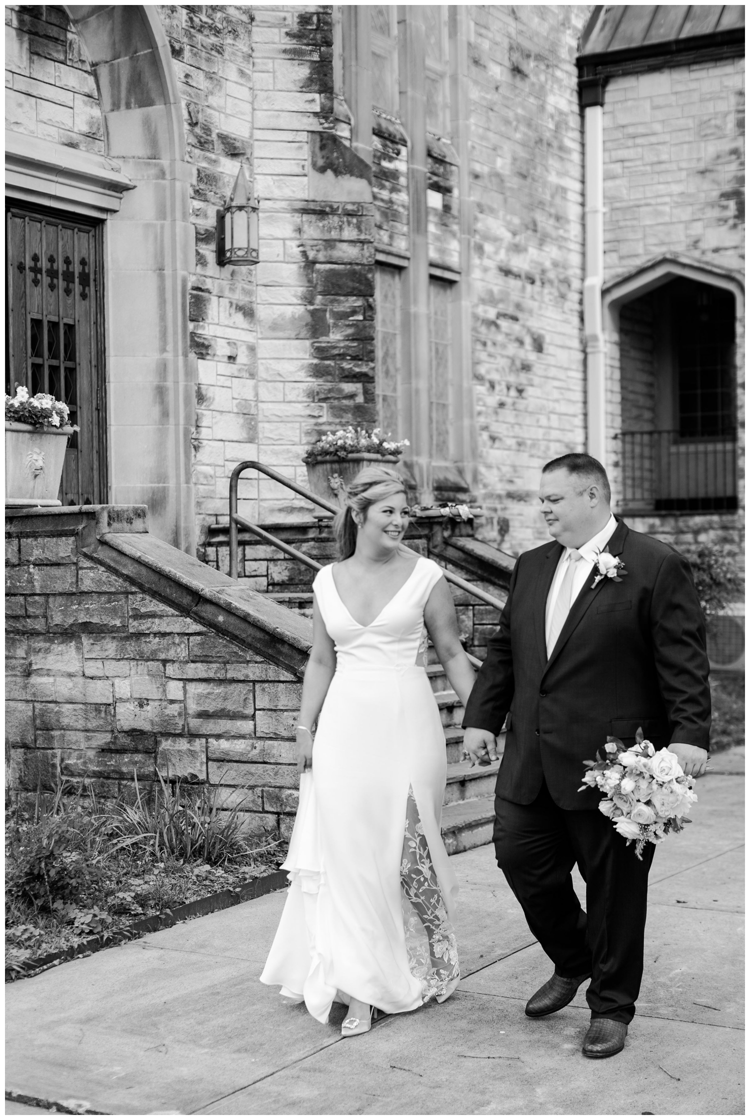 black and white photo of bride and groom holding hands walking at Majestic Metro Wedding Houston