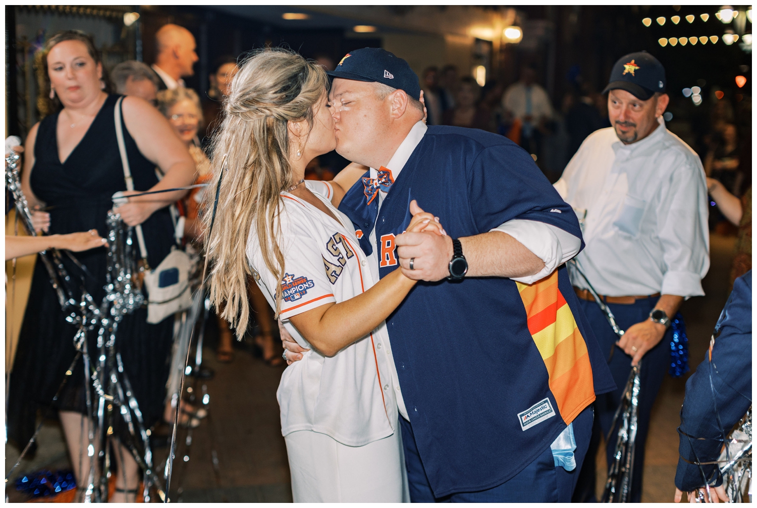 Majestic Metro Wedding with bride and groom kissing and wearing Astros jerseys