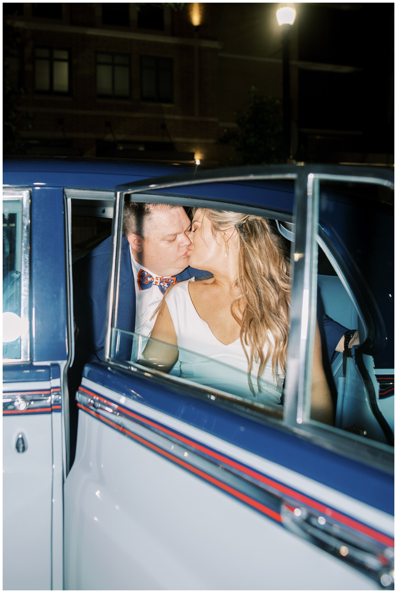 bride and groom kissing inside blue classic car Majestic Metro Wedding