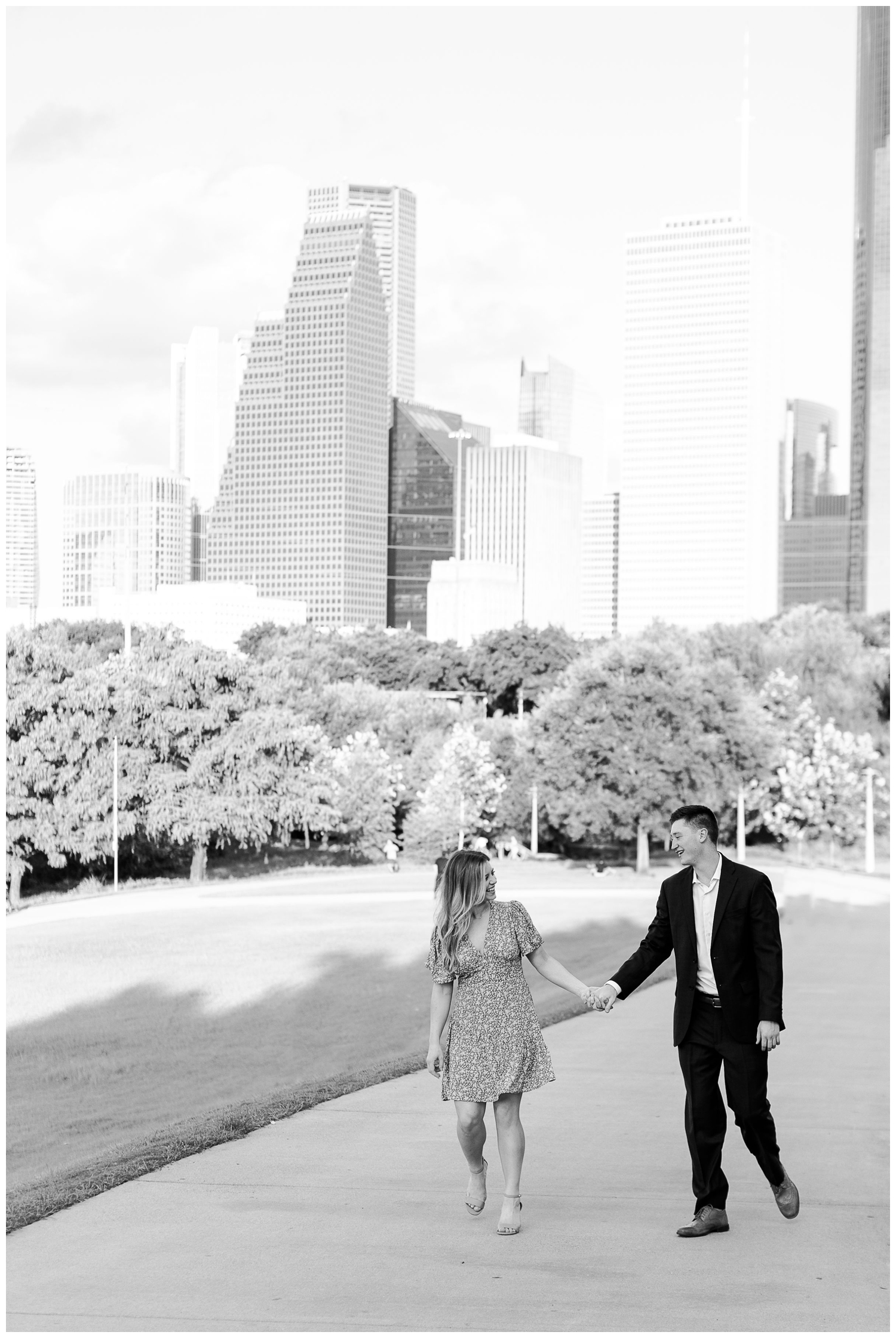 black and white photo of engaged couple holding hands and walking in downtown Houston
