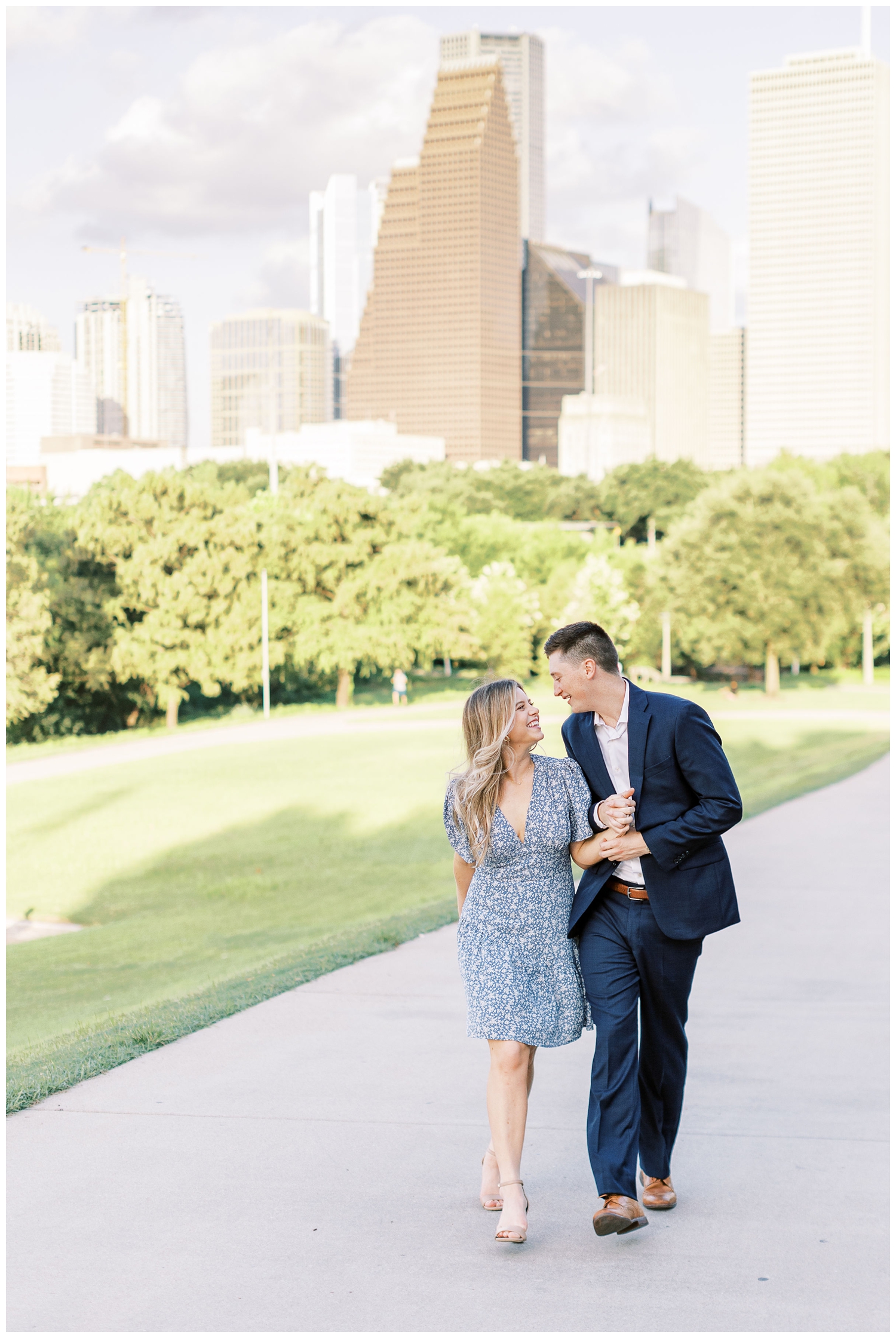couple walking in front of Houston skyline at Eleanor Tinsley engagement session