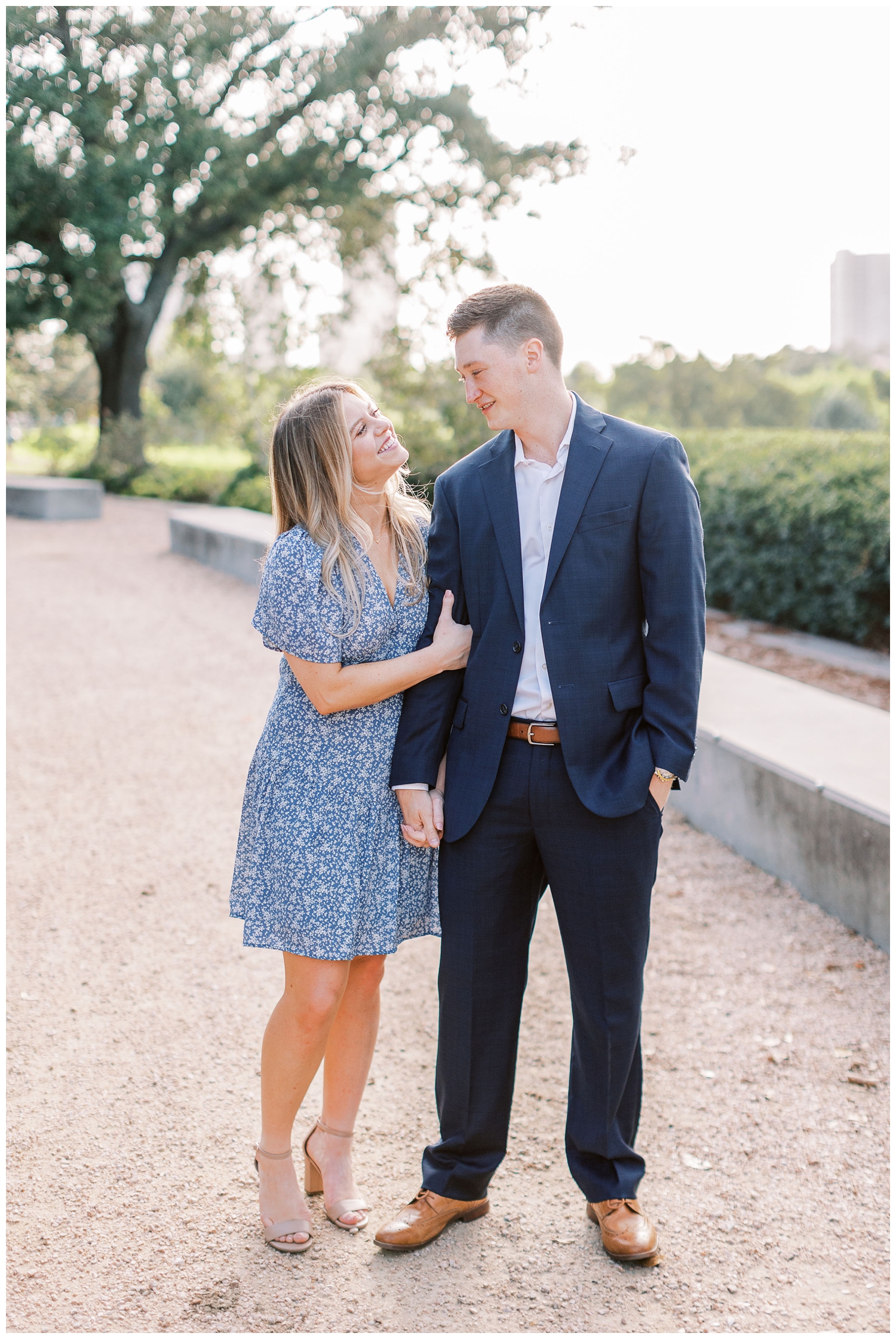 couple smiling at each other in blue dress and blue suit