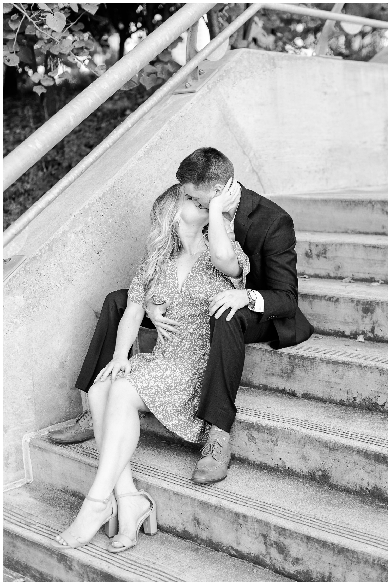 black and white photo of engaged couple sitting on staircase at Eleanor Tinsley Park