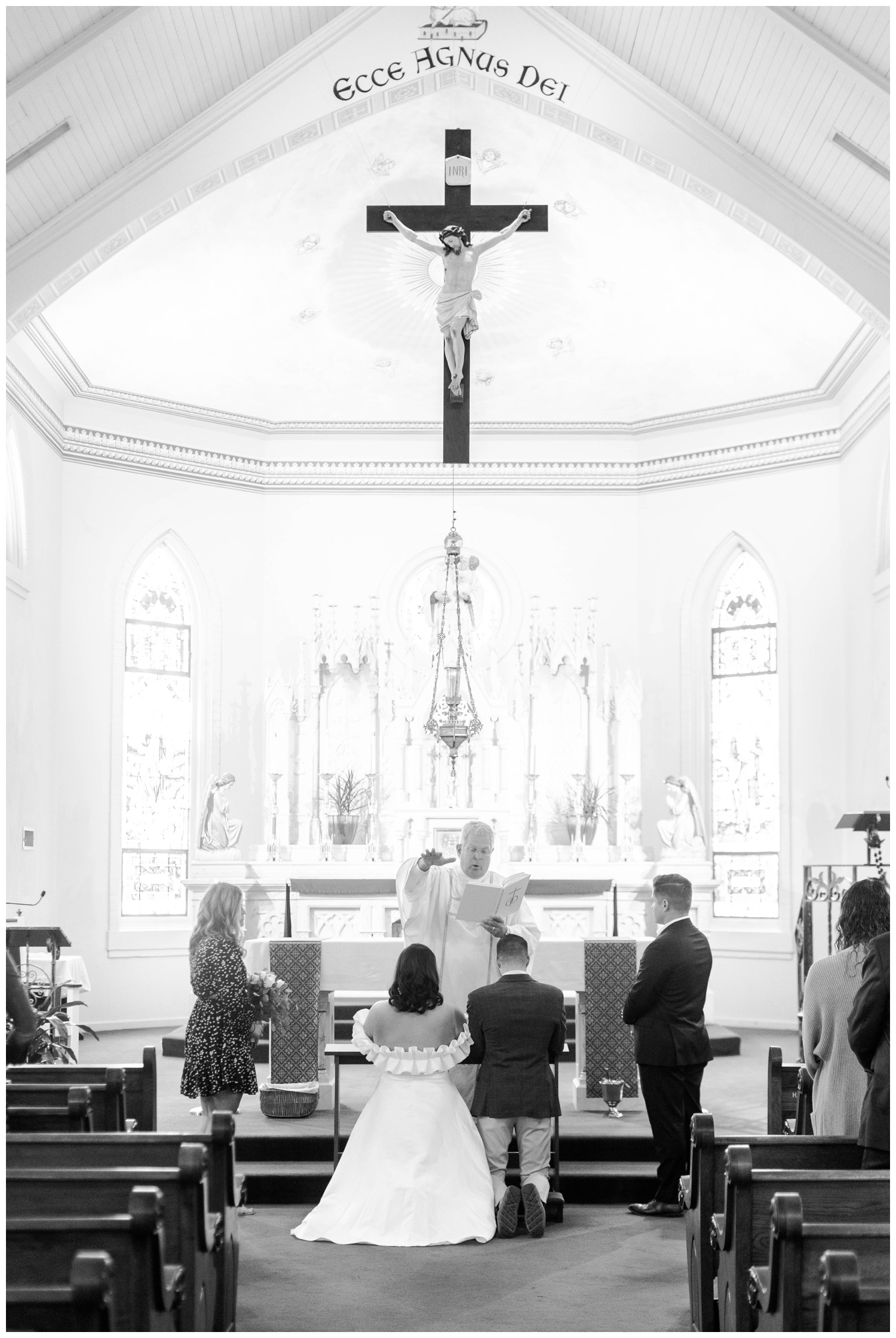 black and white image of bride and groom kneeling at altar