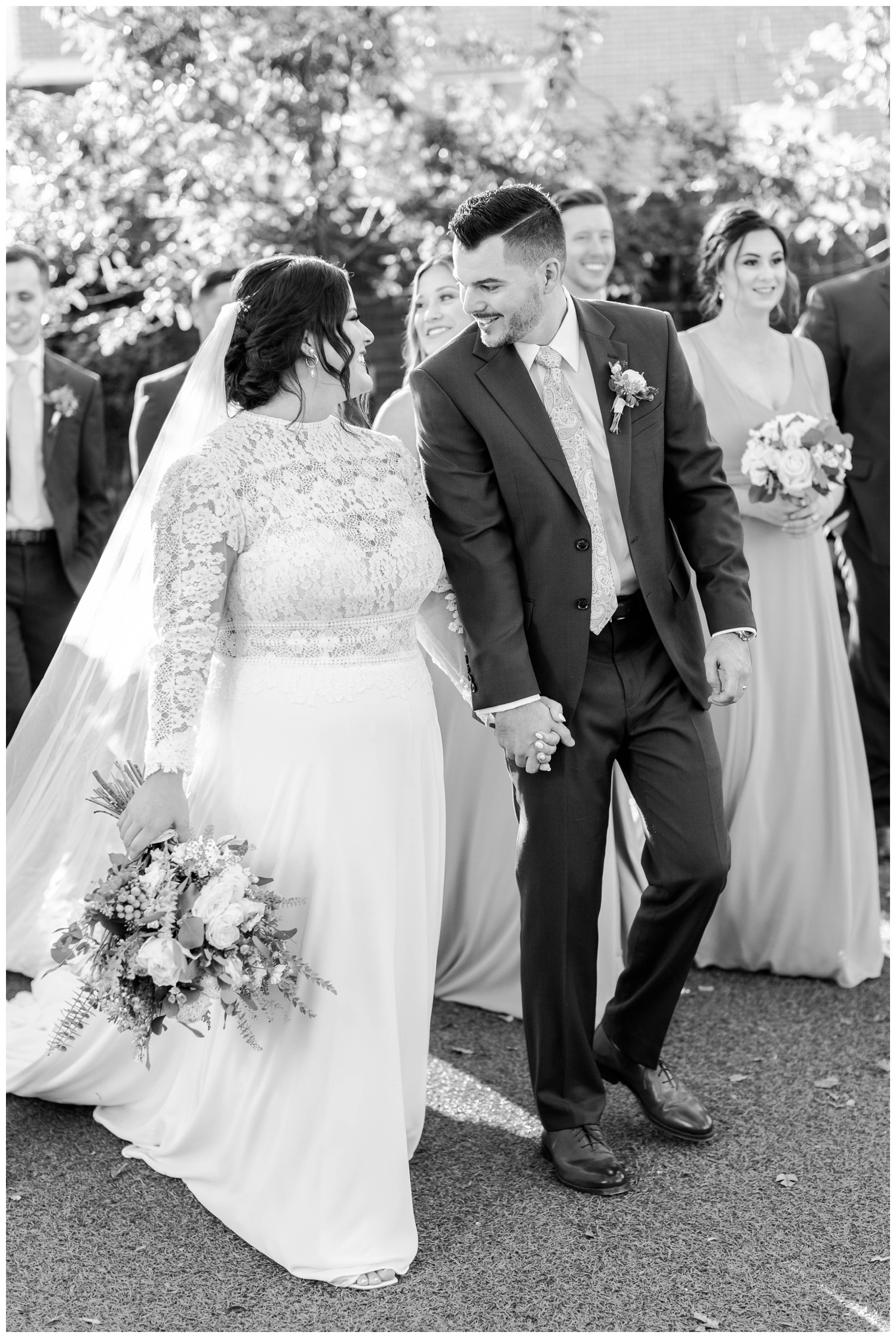 black and white image of bride and groom holding hands and walking Austin Texas outside
