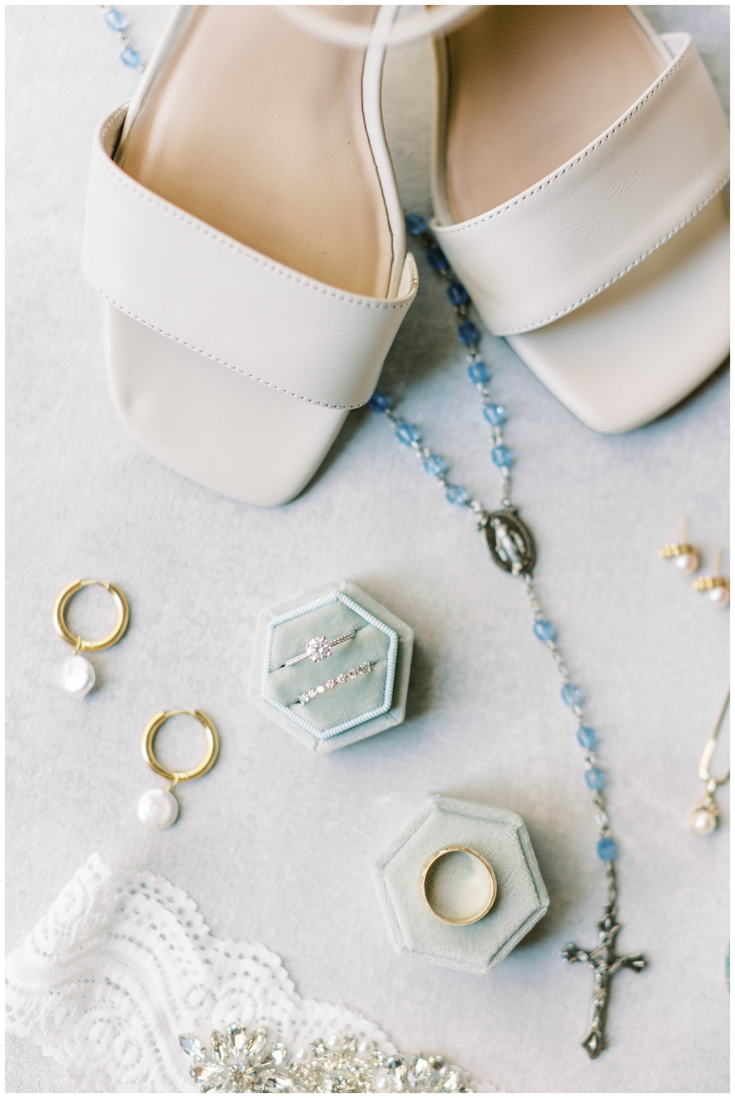 flatlay of bride's details white shoes blue rosary