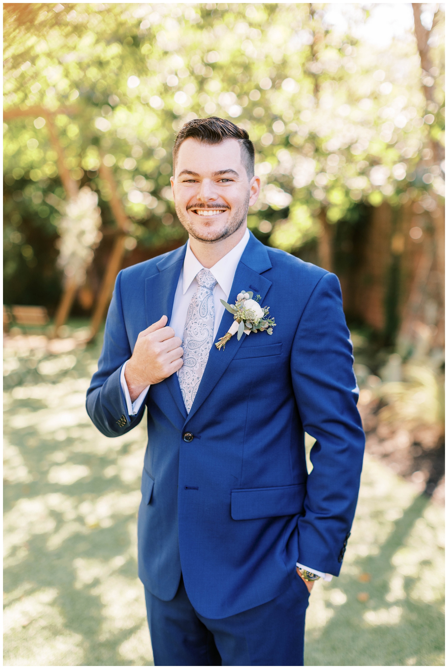 groom in blue tux portrait standing under tree for Austin outdoor wedding