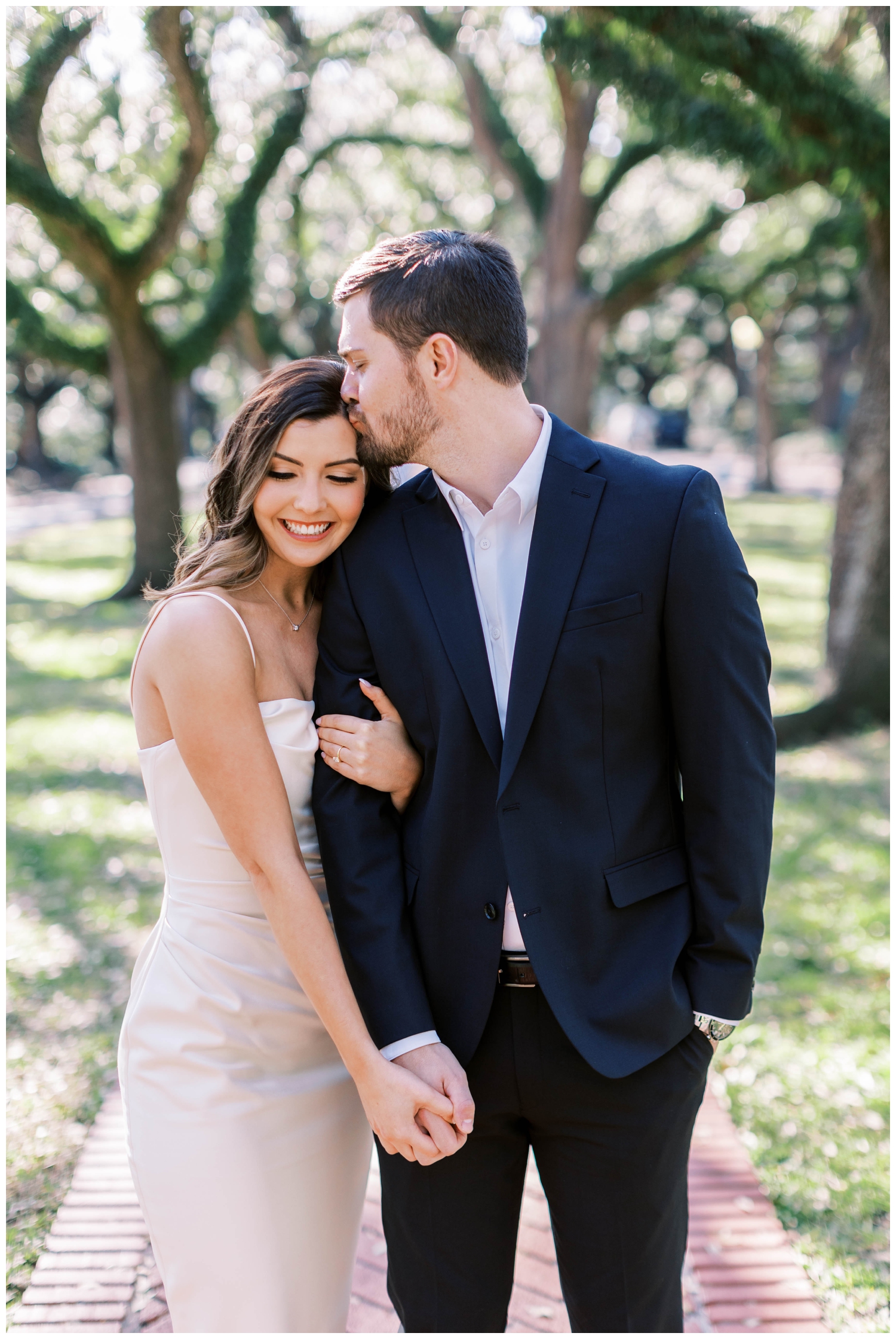 groom kissing his bride Houston engagement outdoor session