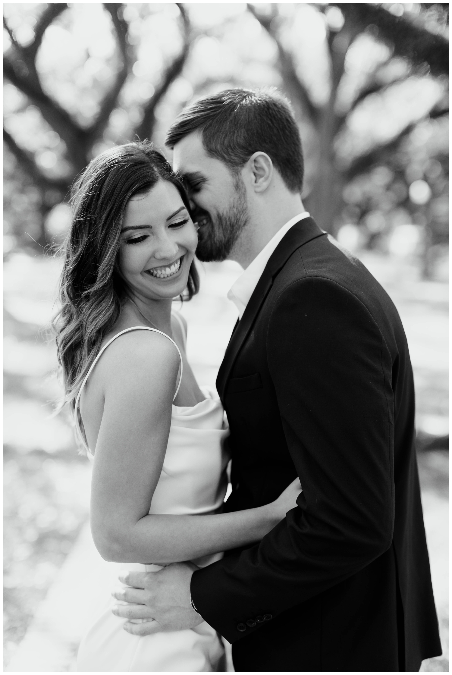 black and white image engaged couple kissing North South Blvd.
