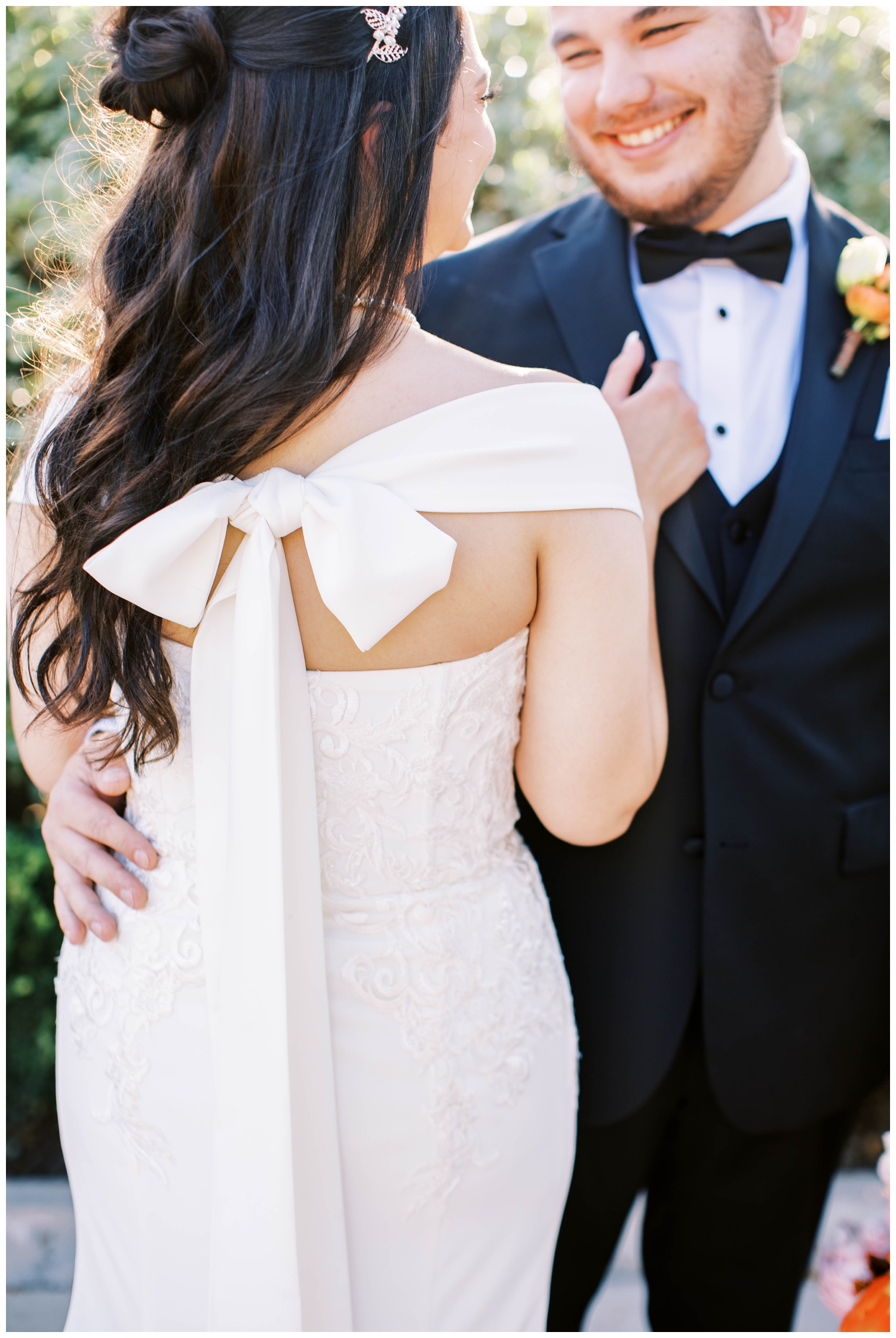 close up of back of brides dress with bow and groom holding her McGovern Centennial Gardens Wedding
