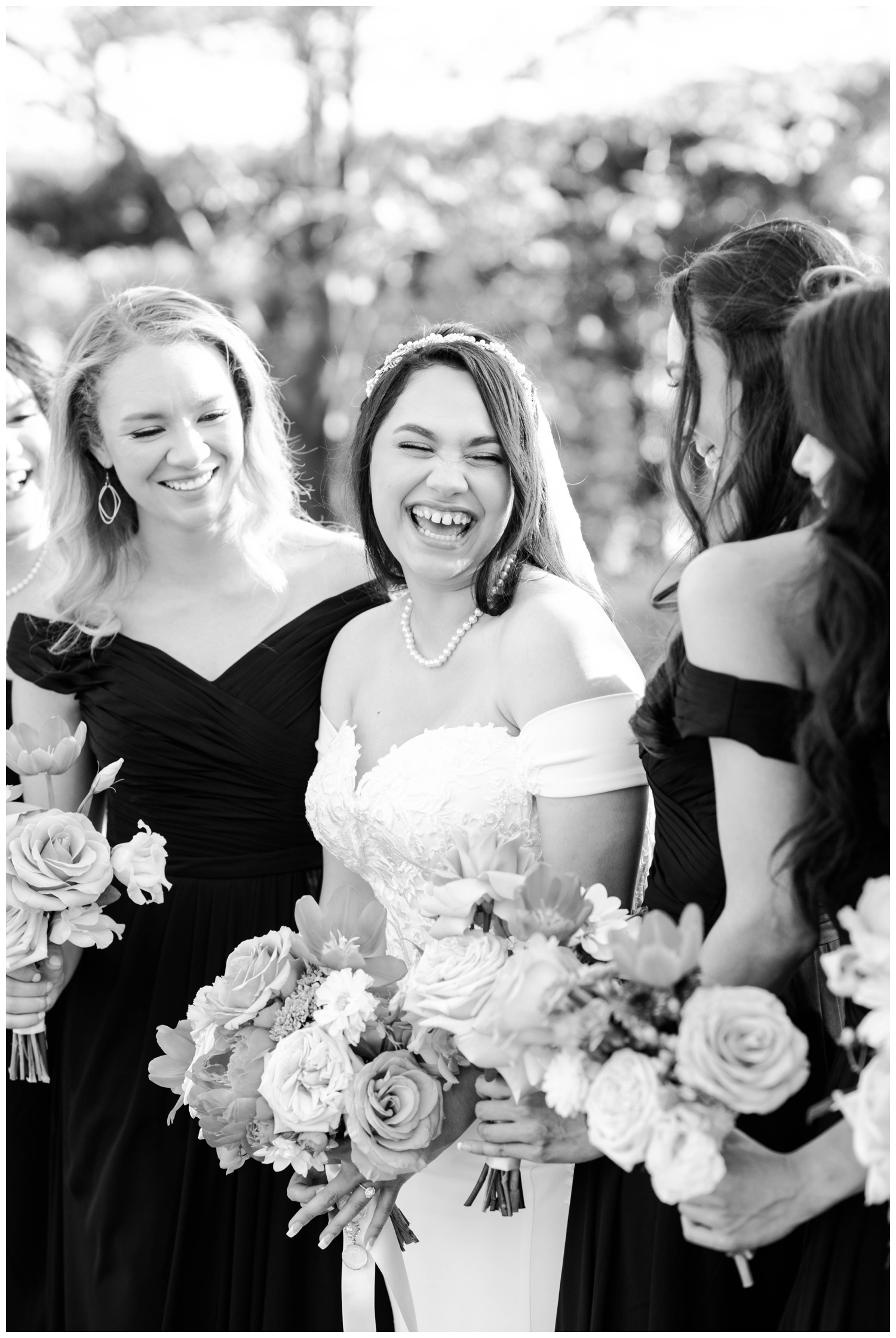 black and white portrait of bride laughing with bridesmaids
