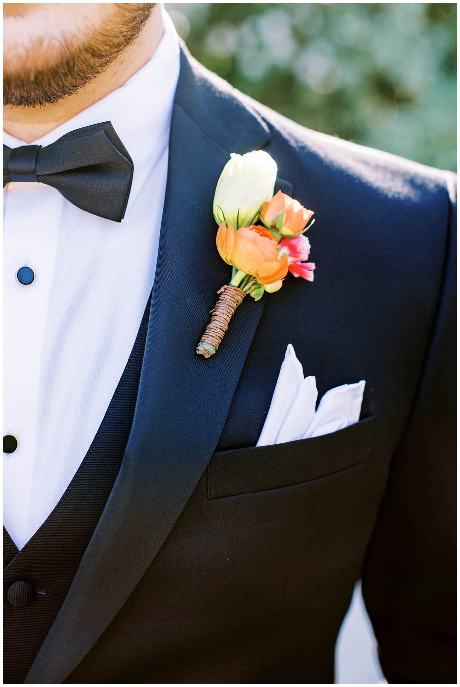 white pink orange boutonniere on grooms lapel