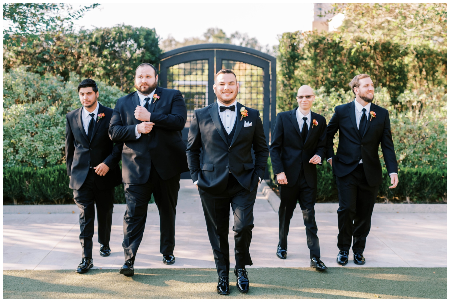 groom and groomsmen walking in front of the doors at McGovern Centennial Gardens outside Hermann Park
