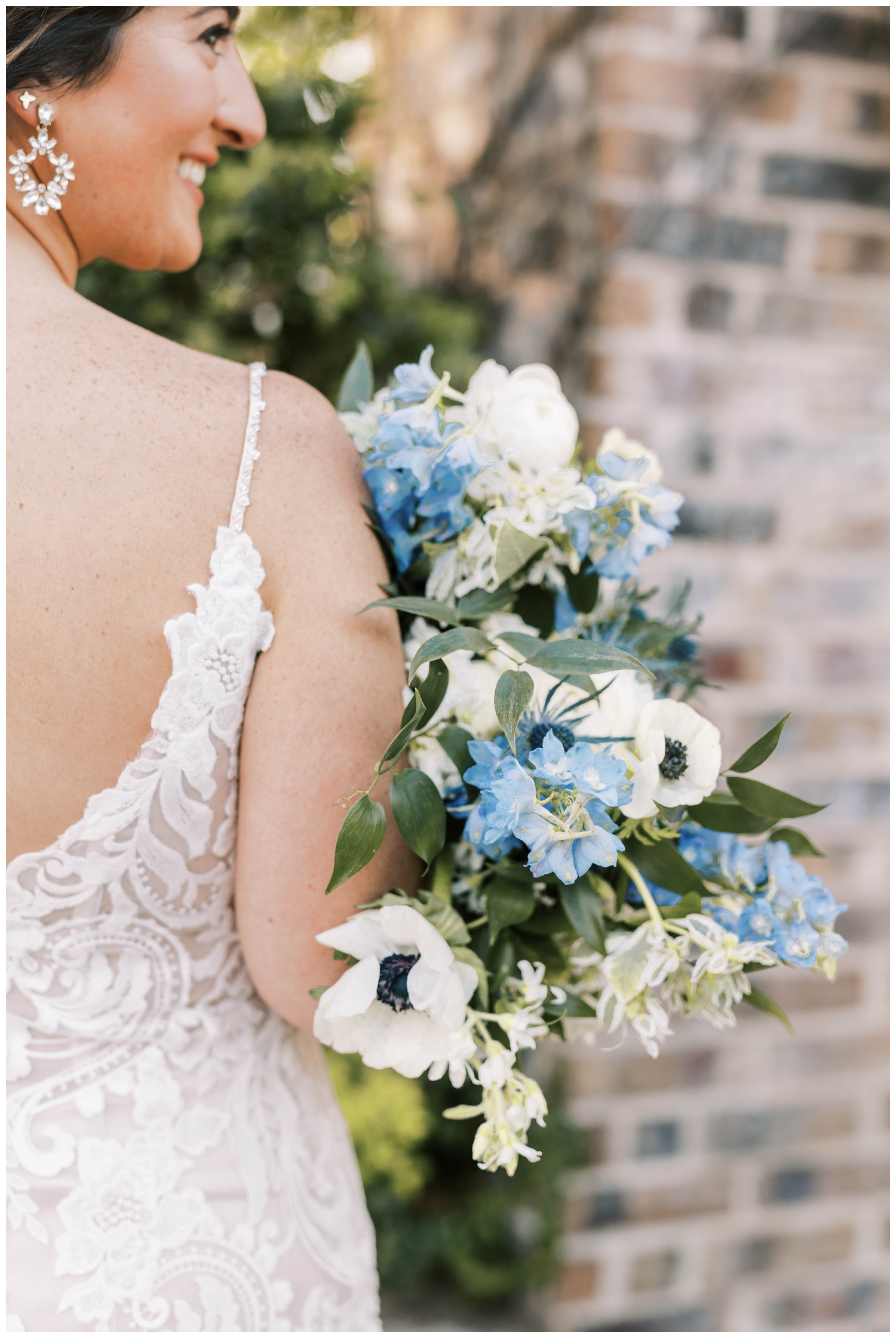detailed image of bride holding white and blue bouquet