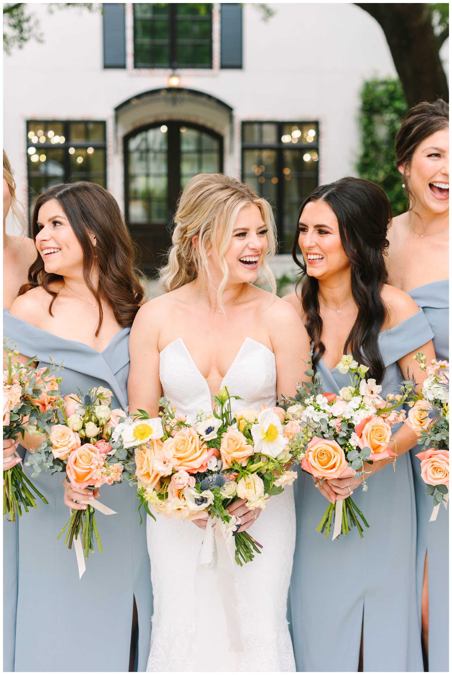 bride laughing with her bridesmaids and floral bouquets outside The Peach Orchard in Woodlands Texas