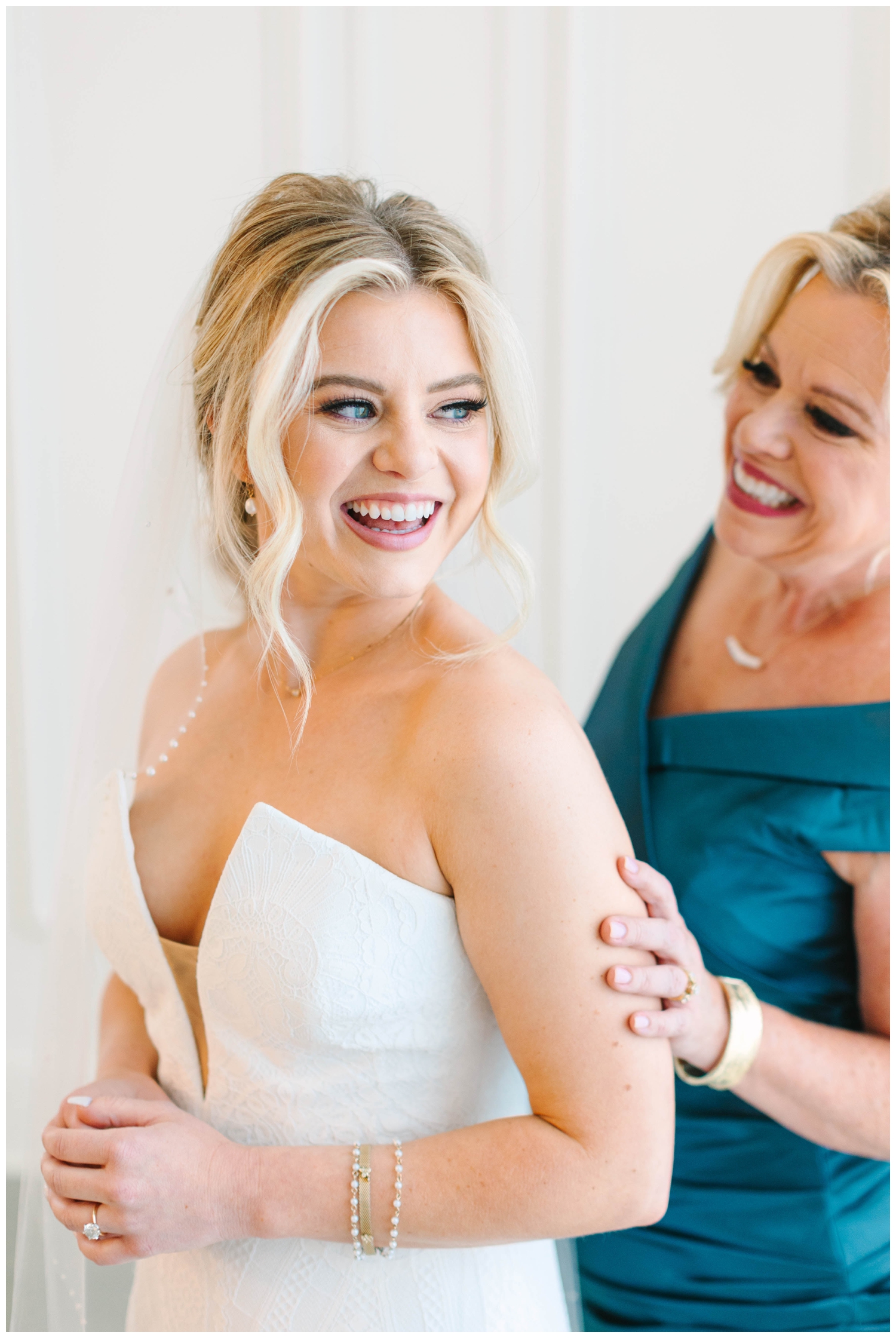 bride getting ready with mom touching her shoulder