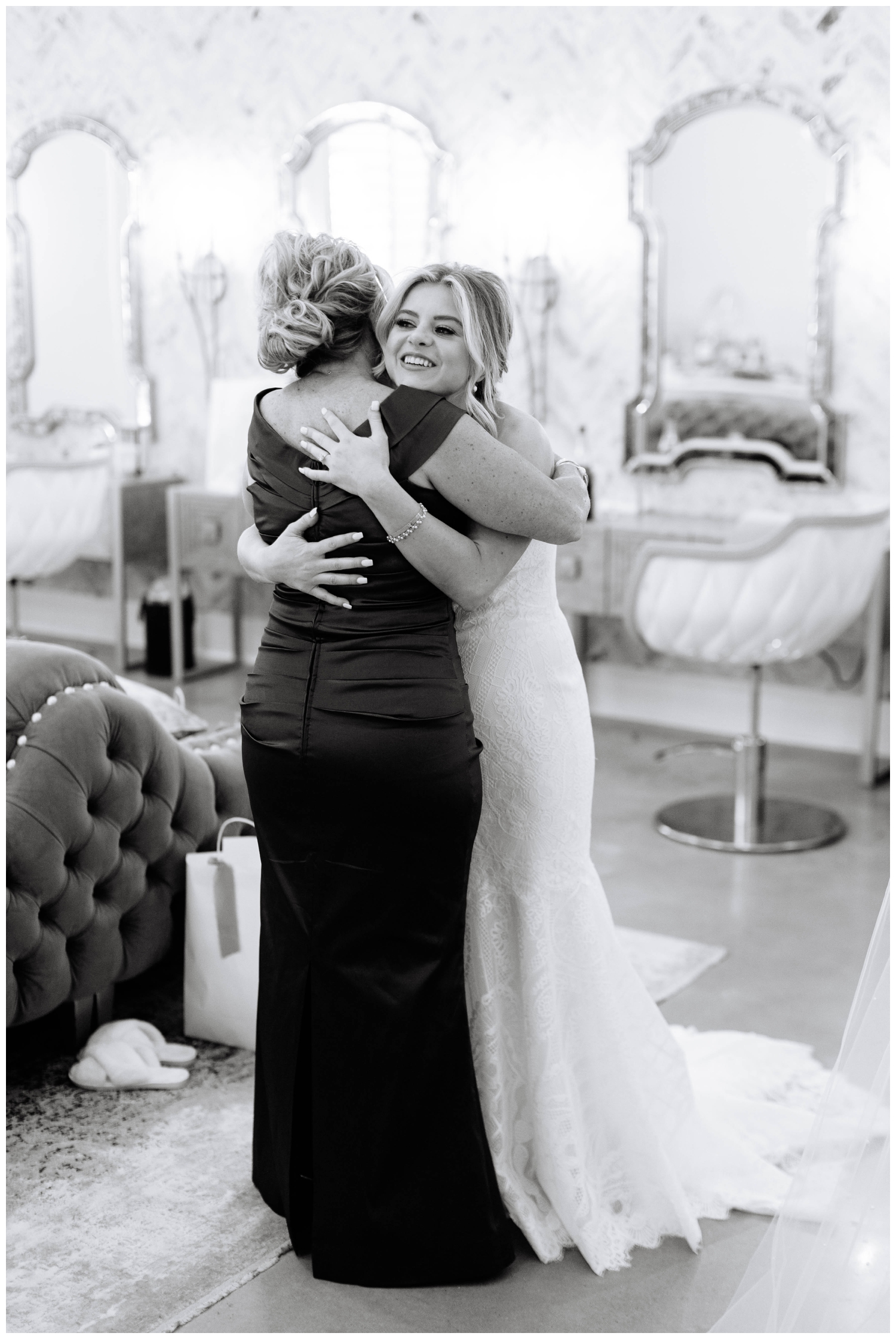 black and white portrait of bride and mom hugging inside Peach Orchard bridal suite in The Woodlands, Texas