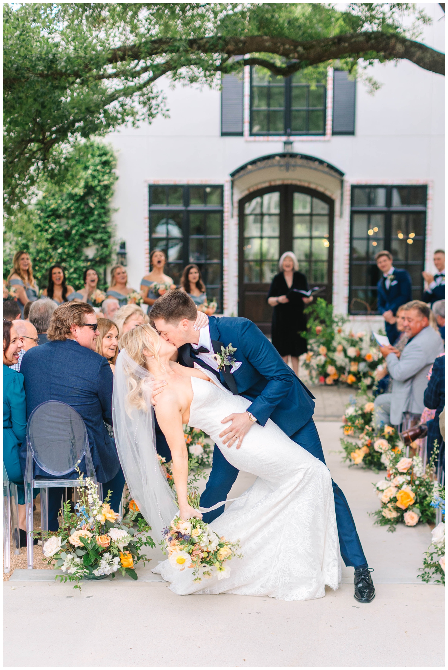 groom dipping his bride and kissing her after wedding ceremony outdoors