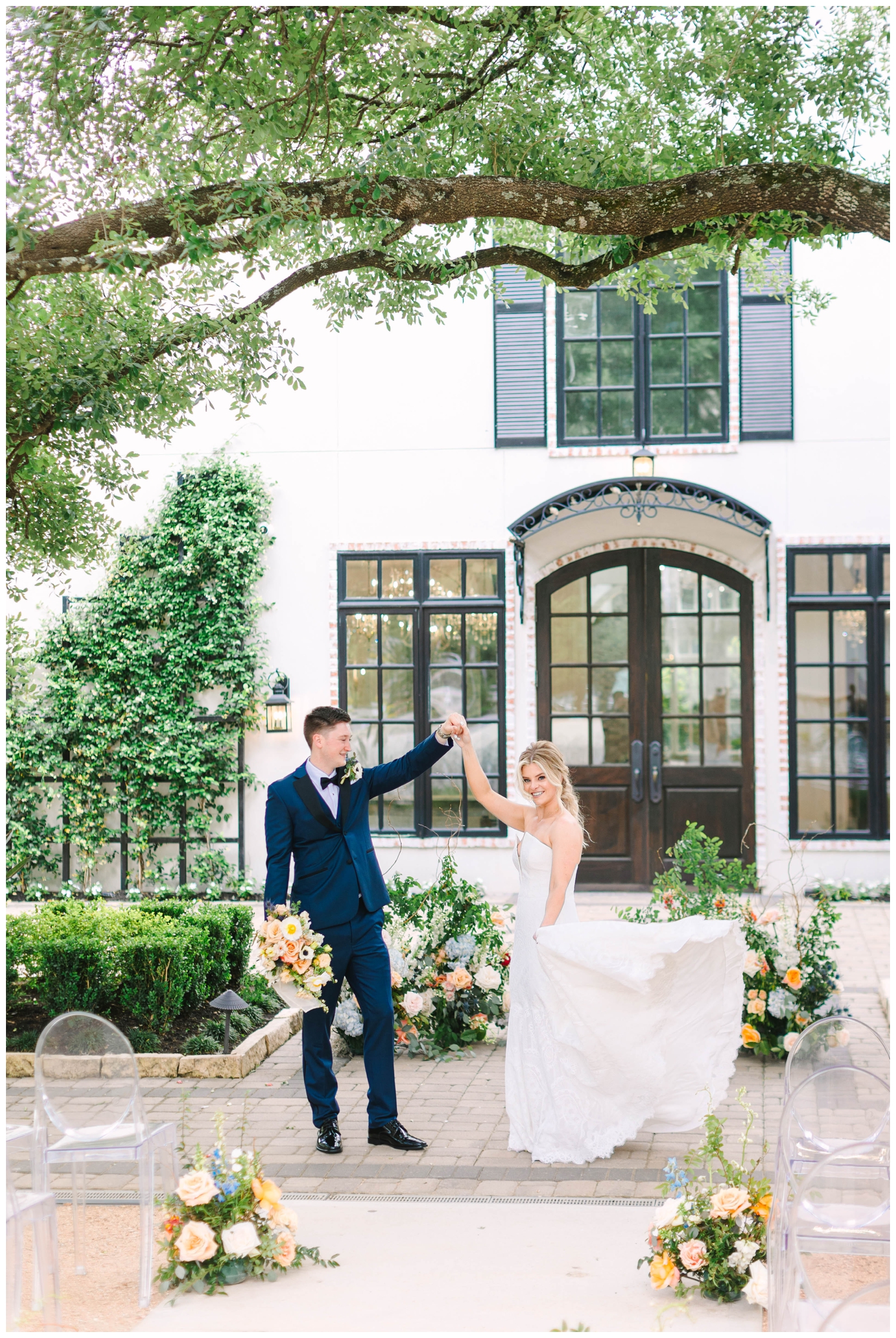 groom twirling his bride outdoors in front of the chapel at The Peach Orchard Wedding Venue