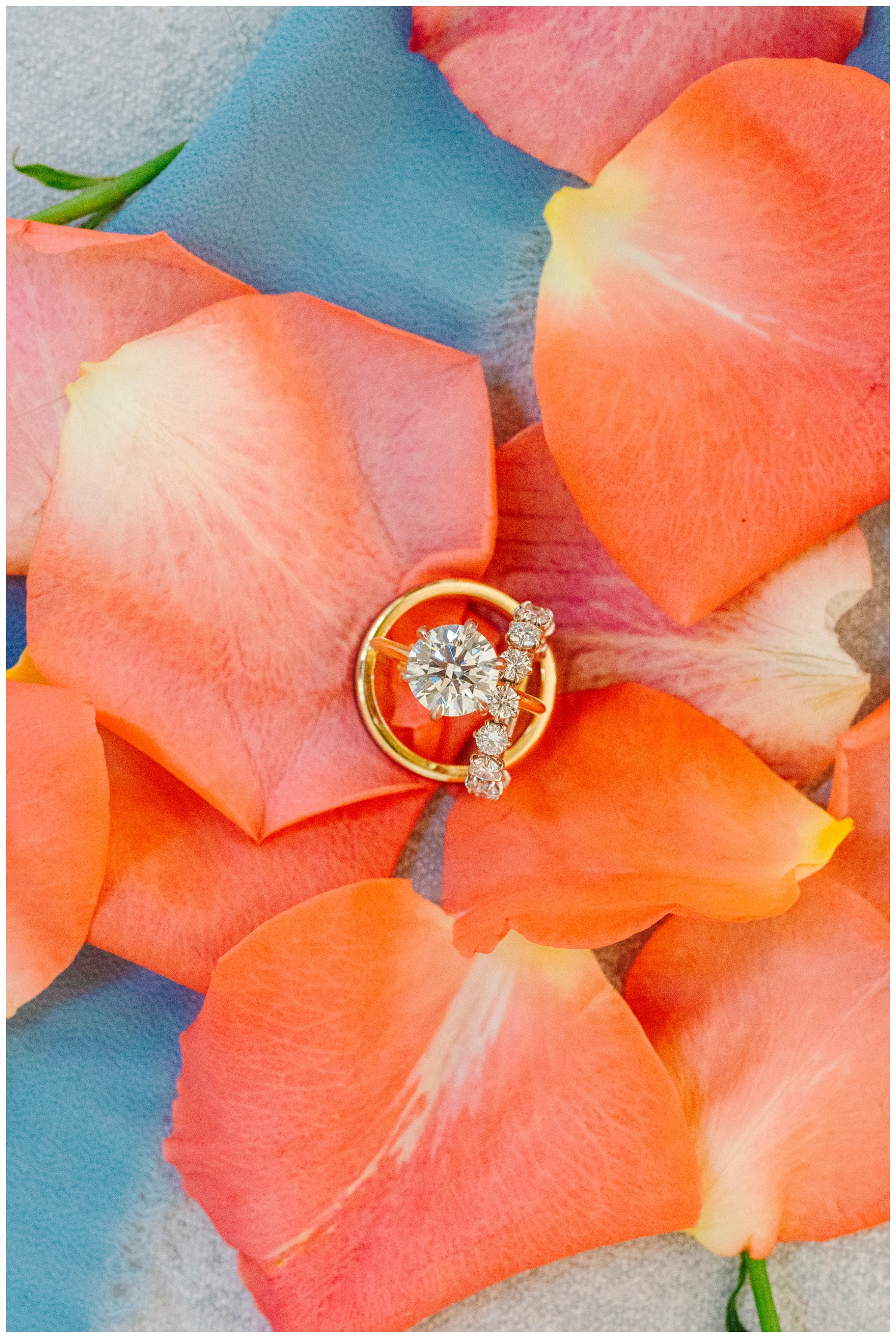wedding ring sitting in orange rose petals