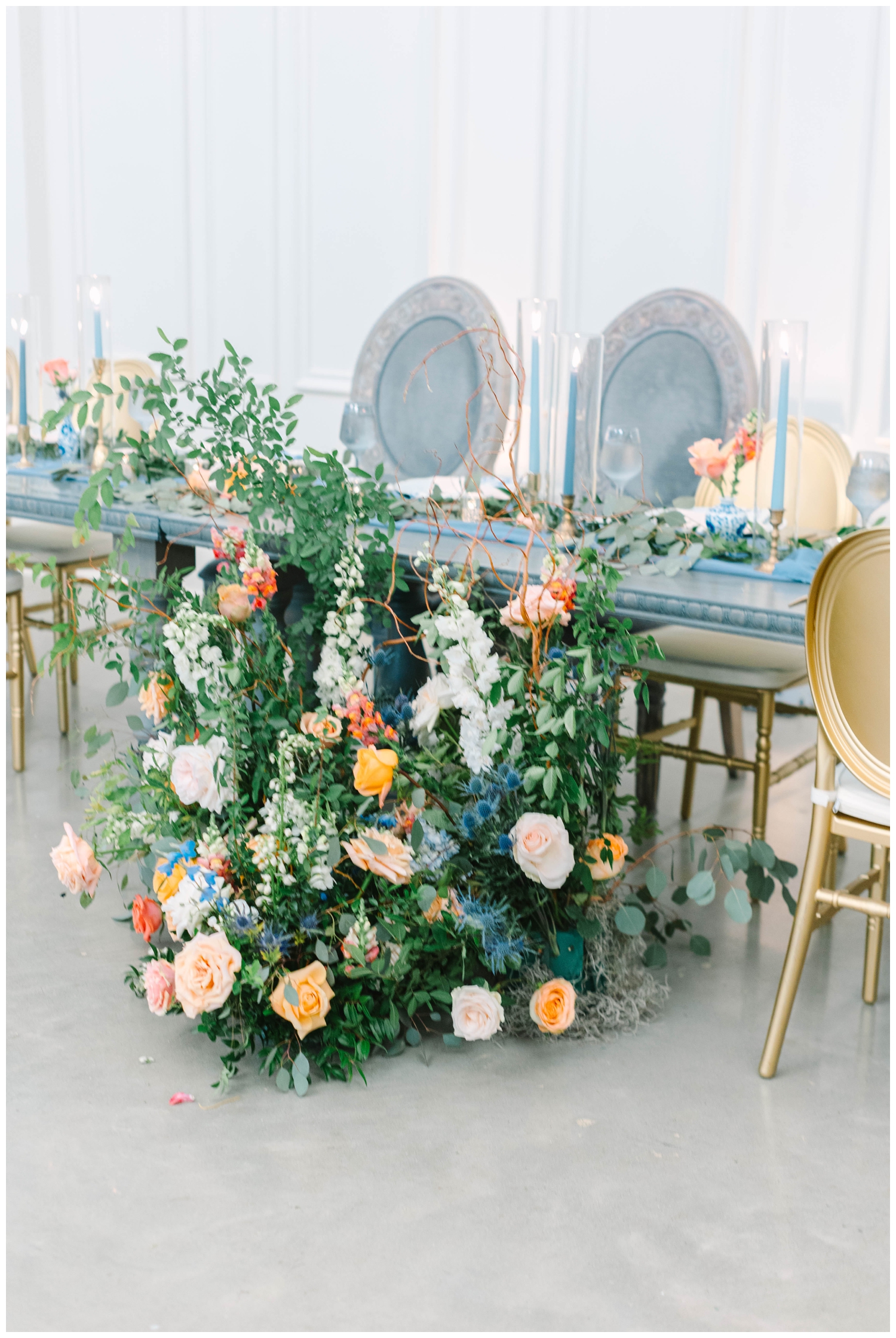 sweetheart table with blue chairs and florals