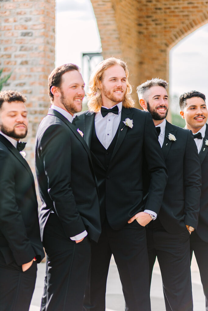 Groom and groomsmen posing for photos from wedding in Houston Texas