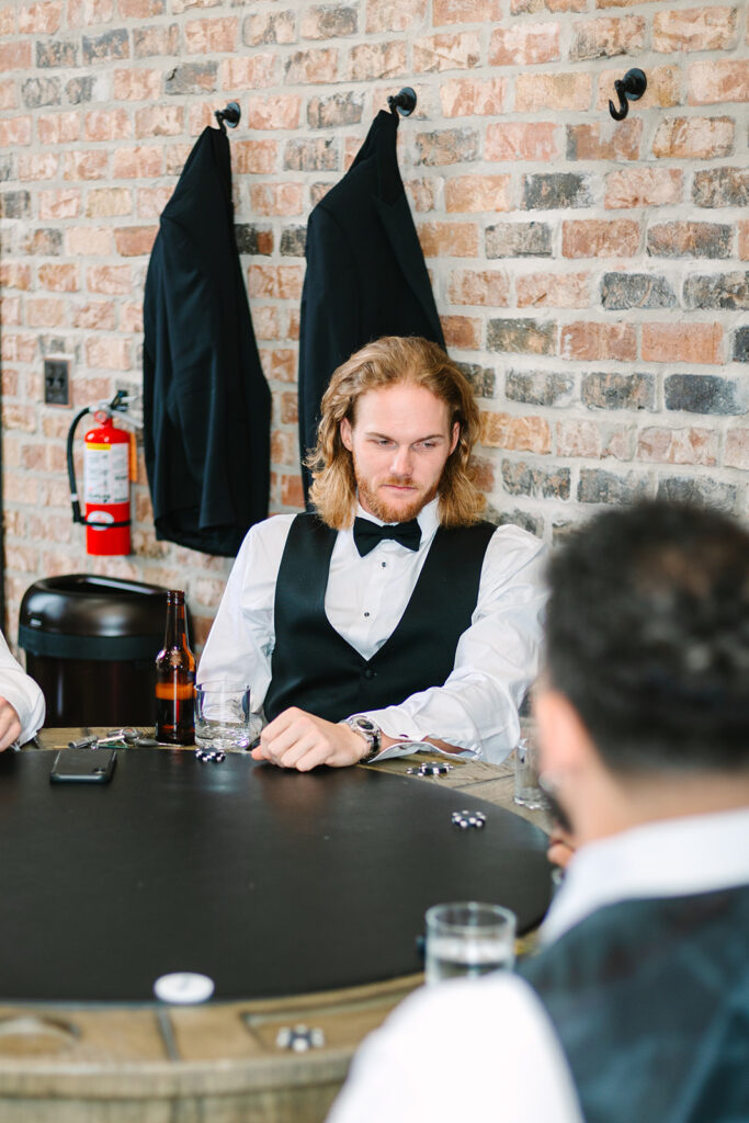 Groom and groomsmen playing cards before wedding ceremony
